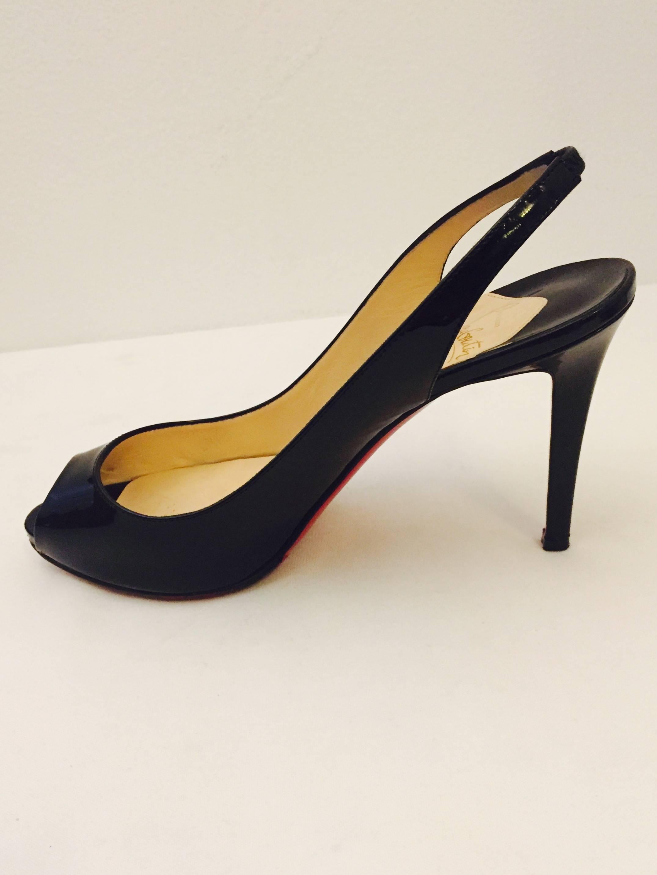 Christian Louboutin 'Private Number' peep toe slingback pumps in black patent leather make a statement with their modern design.  Covered heels with the iconic Red which also covers the soles, elasticized slingback straps for added comfort and a