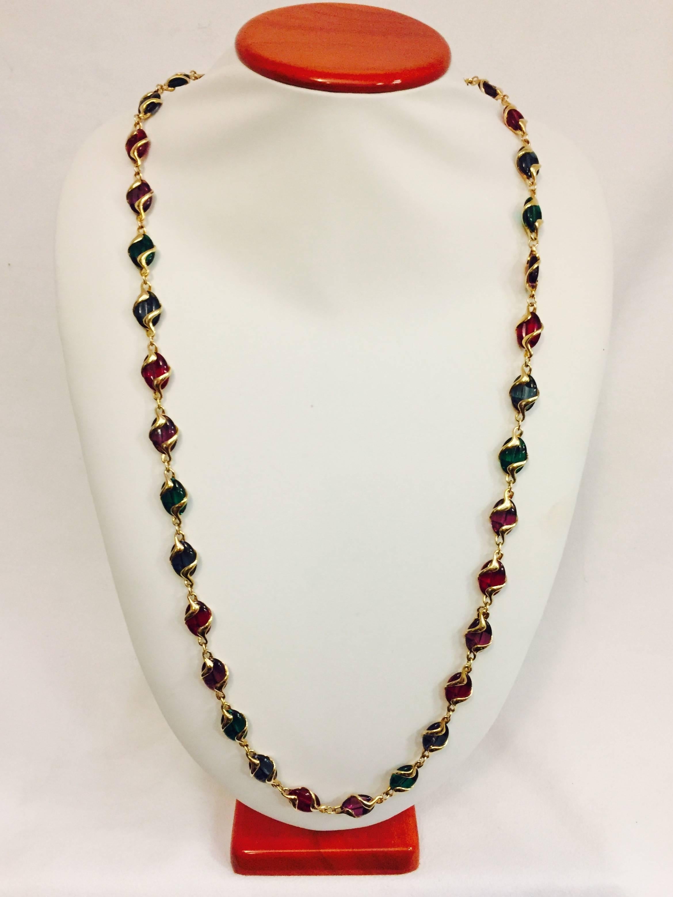 Lovely Swarovski crystal channel links in a variety of festive holiday colors are the foundation of this necklace which also features fine gold link chain.  An ornate, hammered gold tone abstract encasement holds the crystal and provides added