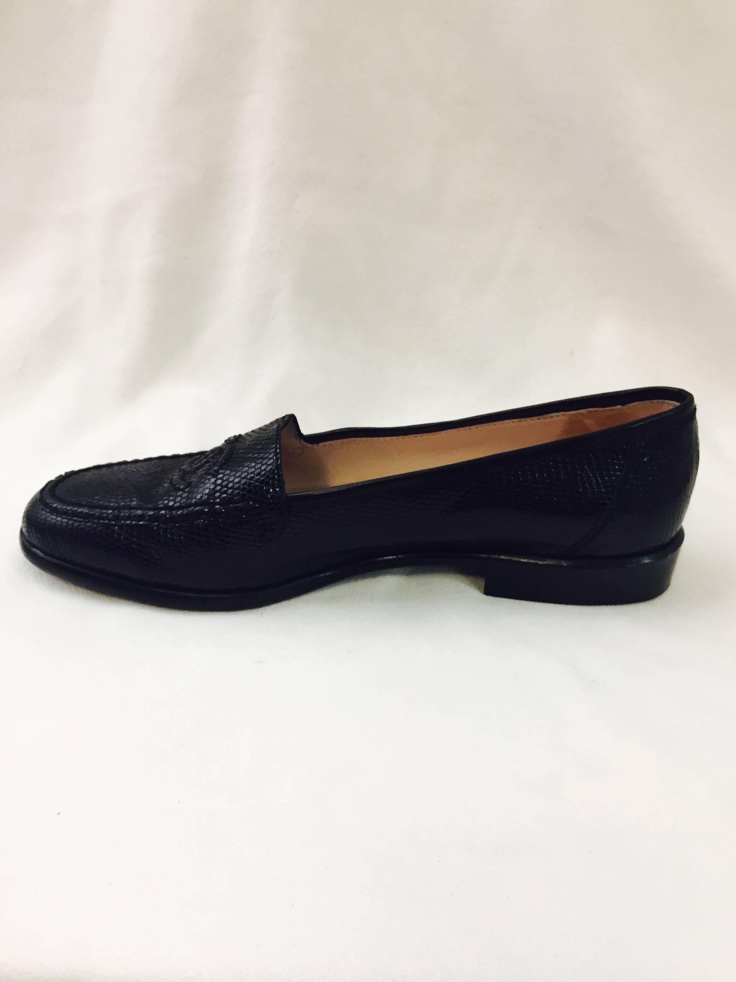 Crafted from luxurious black lizard, these Chanel loafers are anything but basic!  Features tan leather insoles and lining.  Finished with world-renown double 