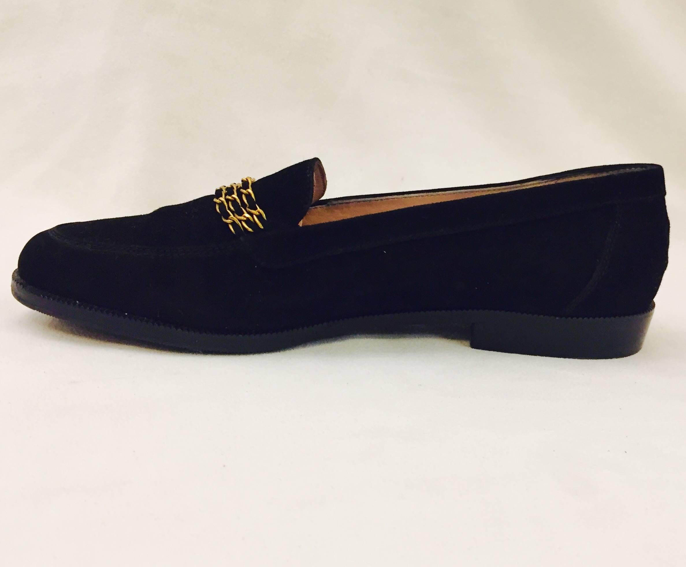 Adorned with three rows of Chanel's highly-coveted leather entwined chains these  black suede loafers are quintessentially chic!  Features black suede uppers and tan leather insole and lining.  Excellent condition. 

Made in Italy