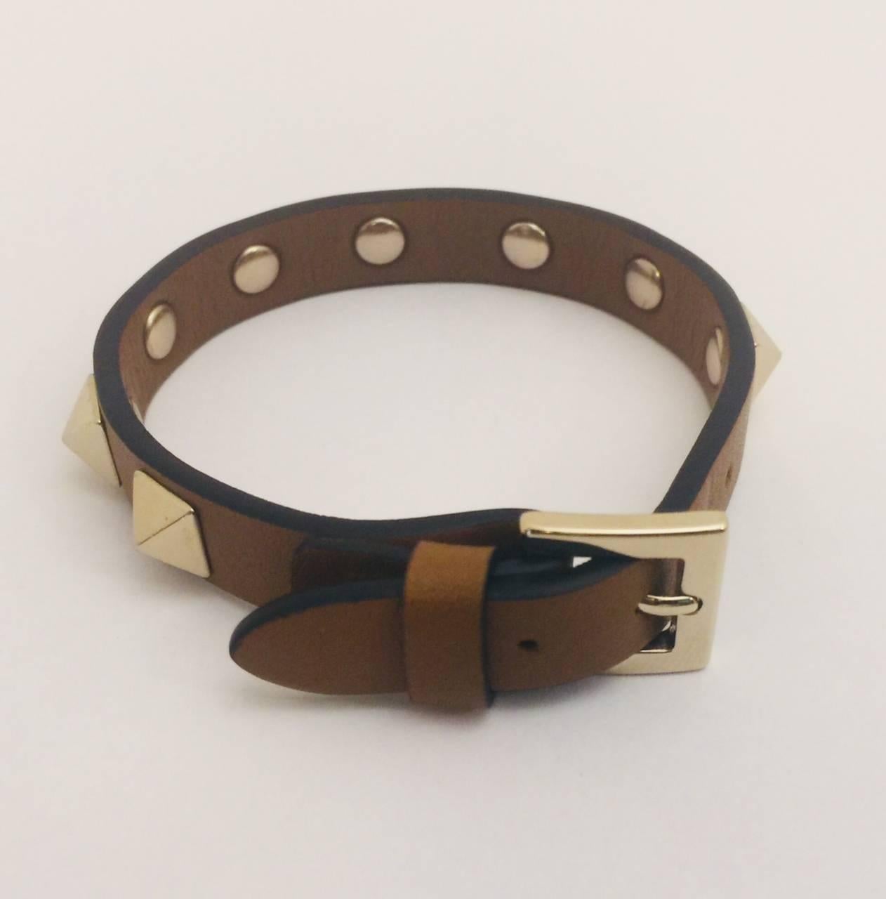 Instantly recognizable!  Narrow caramel color leather bracelet sports Valentino's iconic rock studs.  Adjustable belt buckle closure adjustable from 6.50-7.5