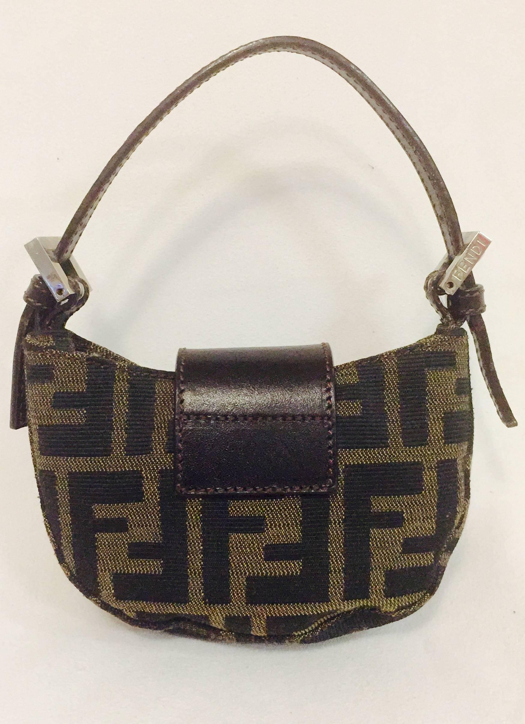 This mini Fendi Zucca Croissant bag says it all: dynamite does come in small packages! This bag is the epitome of City Girl Chic - modern, independent and stylish.  Brown leather flap features iconic Fendi logo and reveals canvas lining. Silver tone