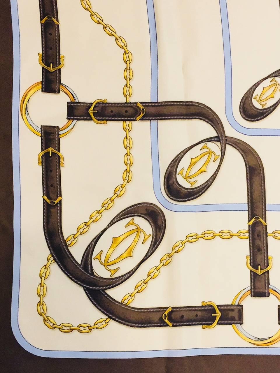Cartier crafts more than some of the world's most highly desired and admired jewels!  Must de Cartier Chocolate and Ivory Equestrian Motif scarf features brown leather straps and iconic gold tone chains and hardware fit for any grand procession of