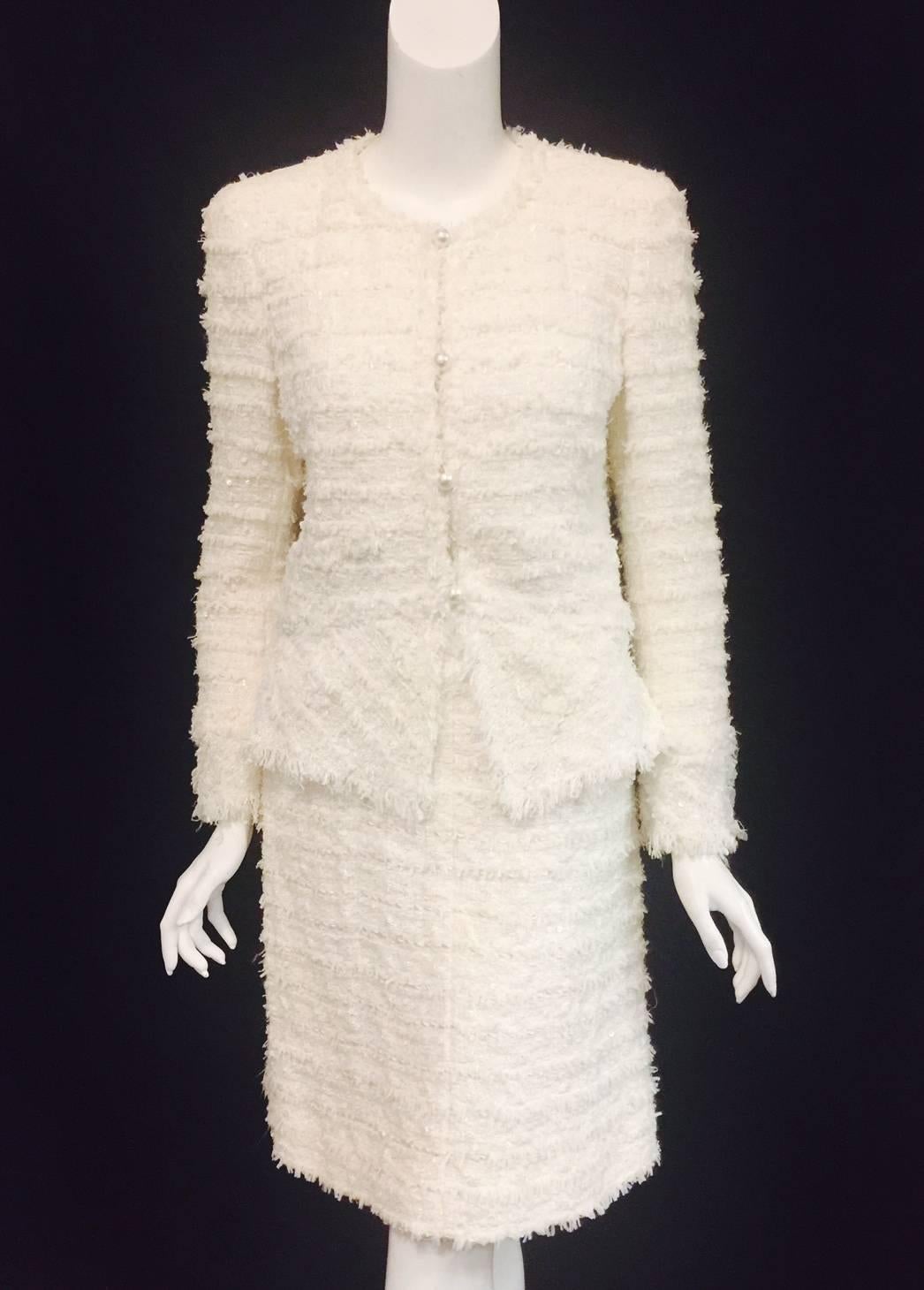 This fabulous Chanel tweed boucle suit with multiple shades of winter white is interwoven in a summer weight confetti tweed, fringed, and then interlaced again with tiny white sequins. The fabrication is pure couture! The jacket buttons down the