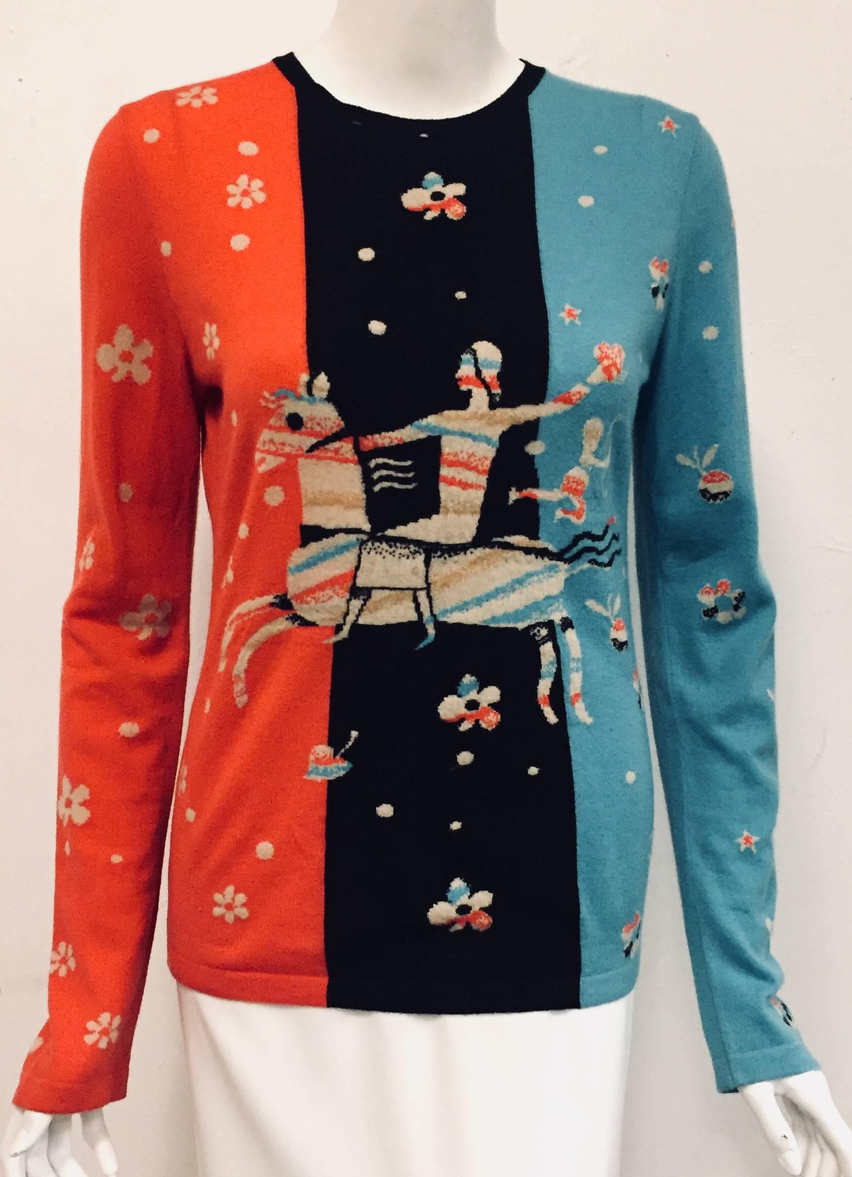 Chanel cashmere pullover sweater with whimsical print of man on a horse and Cupid with his arrow?  It's Chanel being playful!  This round collar sweater with black knit trim and long sleeves features one in red and the other in turquoise.  The front