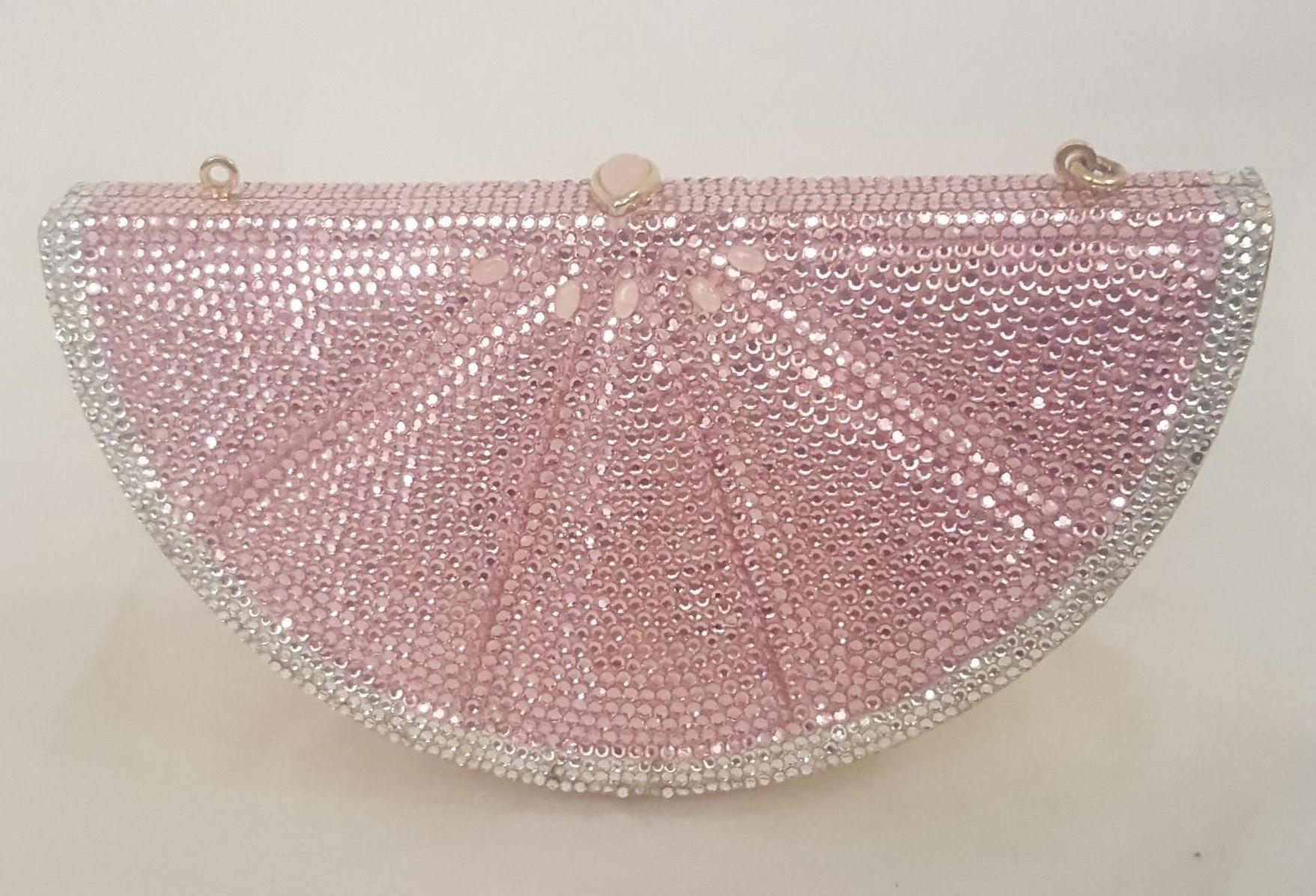 This glittering crystal grapefruit slice Judith Leiber clutch is made from pink and white Austrian crystals.  The  grapefruit slice is highlighted with a gold tone frame silhouette resembling the outer skin.  This bag has a seed shape push lock