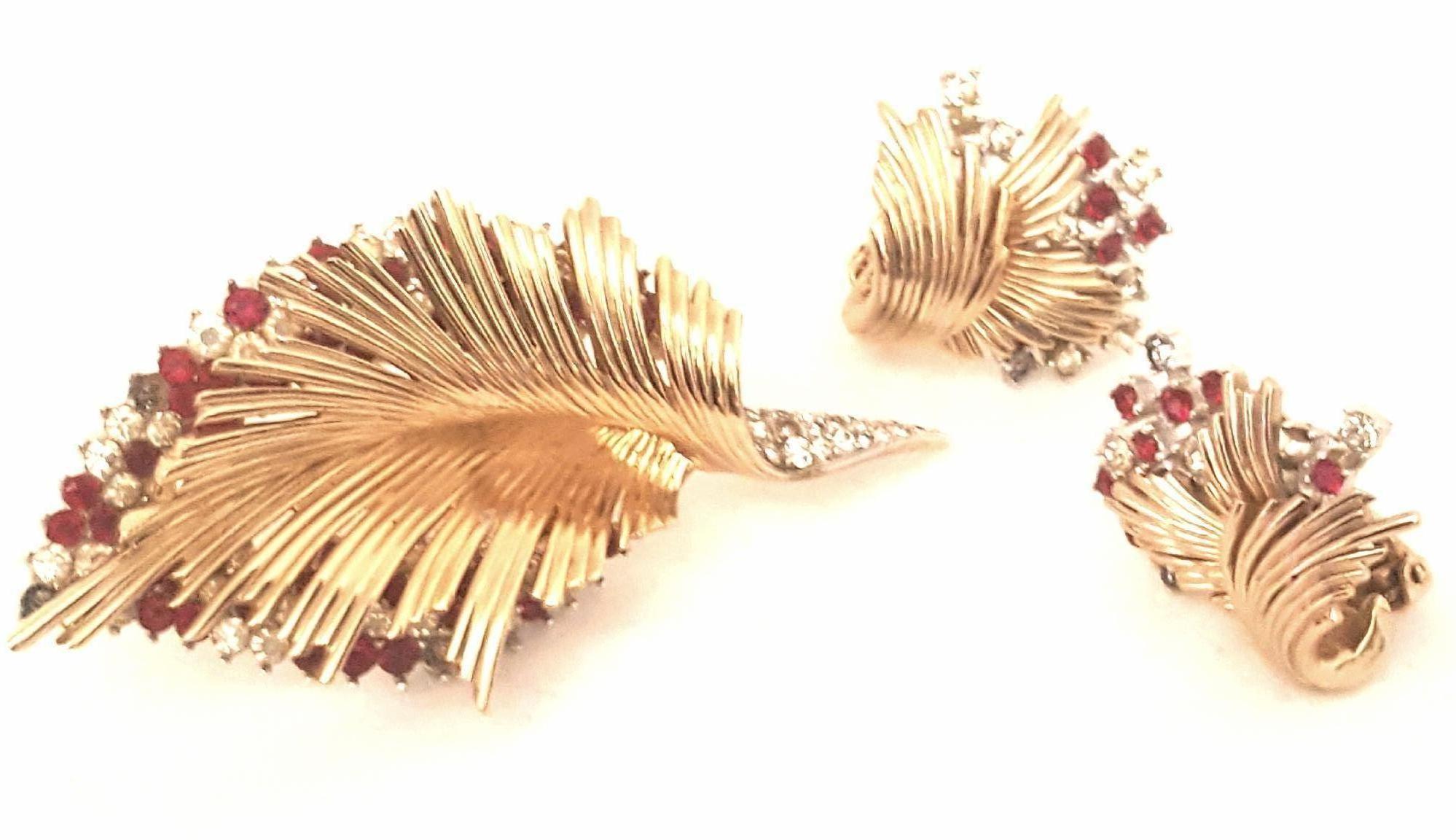 Vintage yet contemporary!  This brooch and clip on earrings demi parure. Boucher made a name for himself creating bold, imaginative pieces that were individual works of art.  Fabricated in gold tone and beautifully rhodium finished, this set boasts