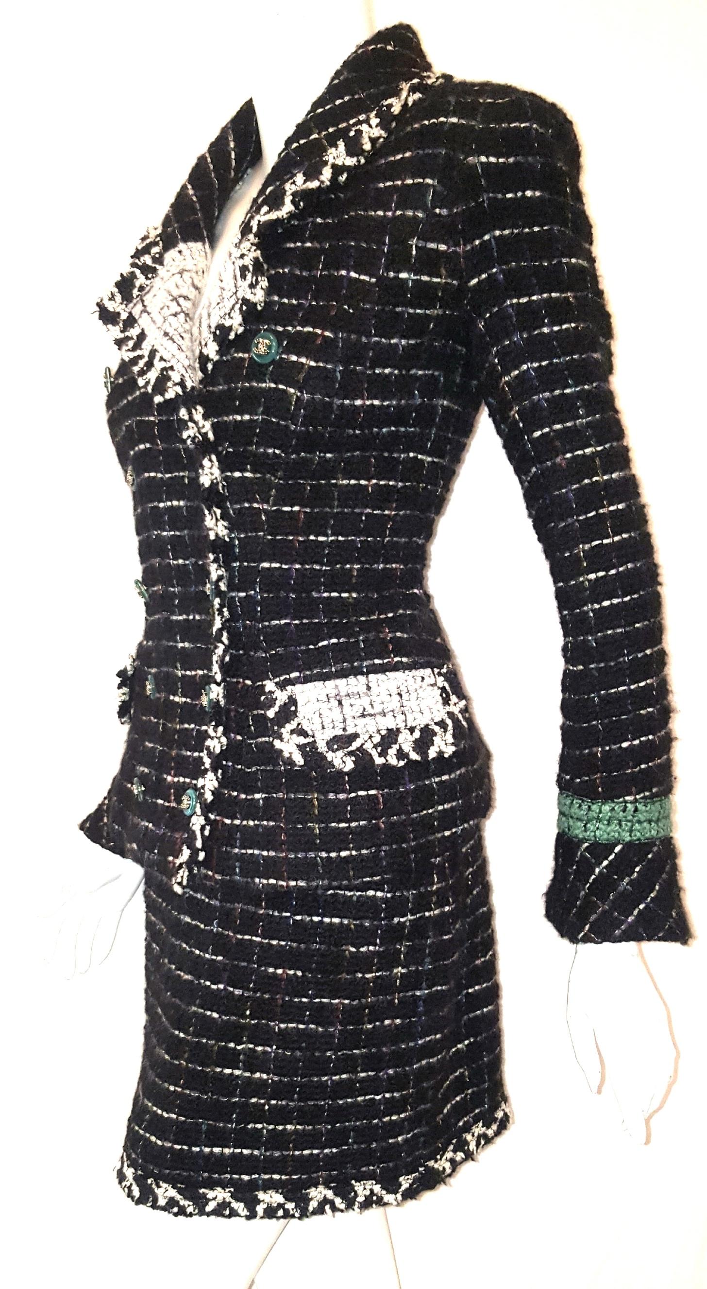Chanel black and white metallic tweed with multi color threads woven to show grid lines in metallic silver, gold tone and dark green, almost reminds us of mosaic tile work. The detailing is beautiful with touches including a high black tweed collar,