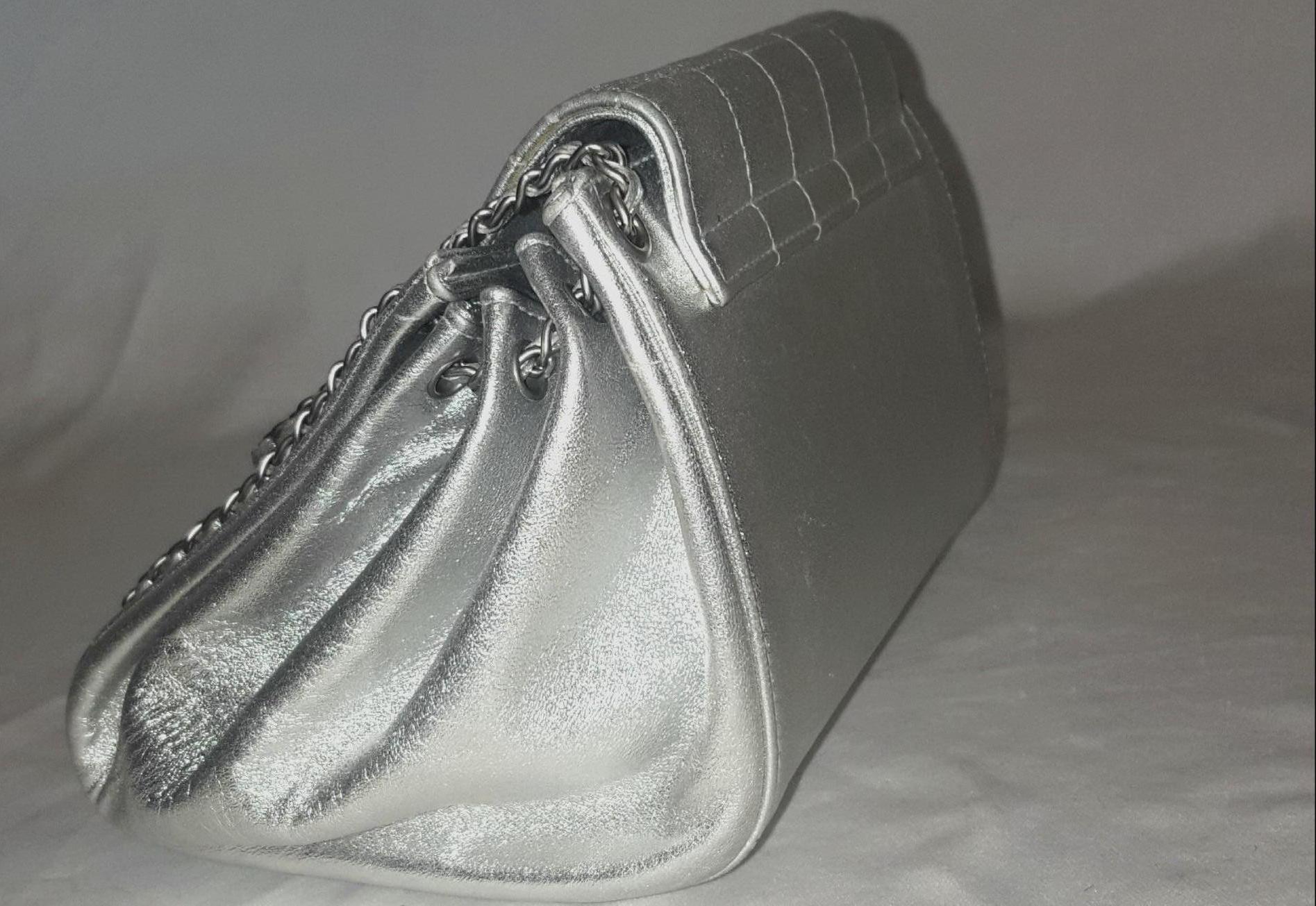 Chanel vintage Mademoiselle silver metallic square quilt accordion mini bag is as stylish today as the day it was launched.  This shoulder bag is crafted of silver metallic lambskin leather with square quilting on the flap that has a turn lock on