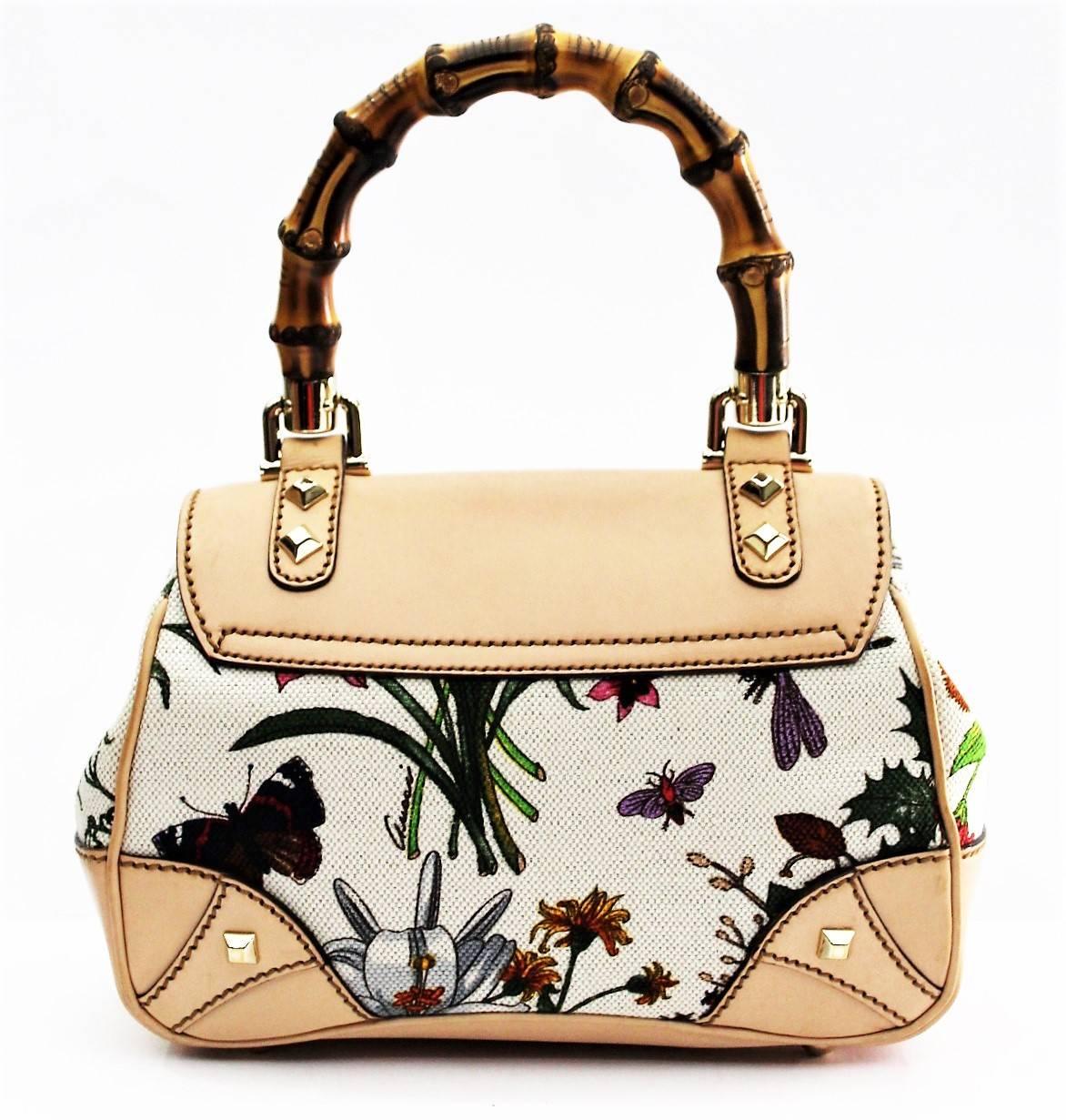 This chic tote is crafted of bright floral print canvas. The bag features a looping bamboo top handle and leather treatment in a light tone with base corners and a half frontal flap with a bamboo turn lock and brass hardware. This opens to a