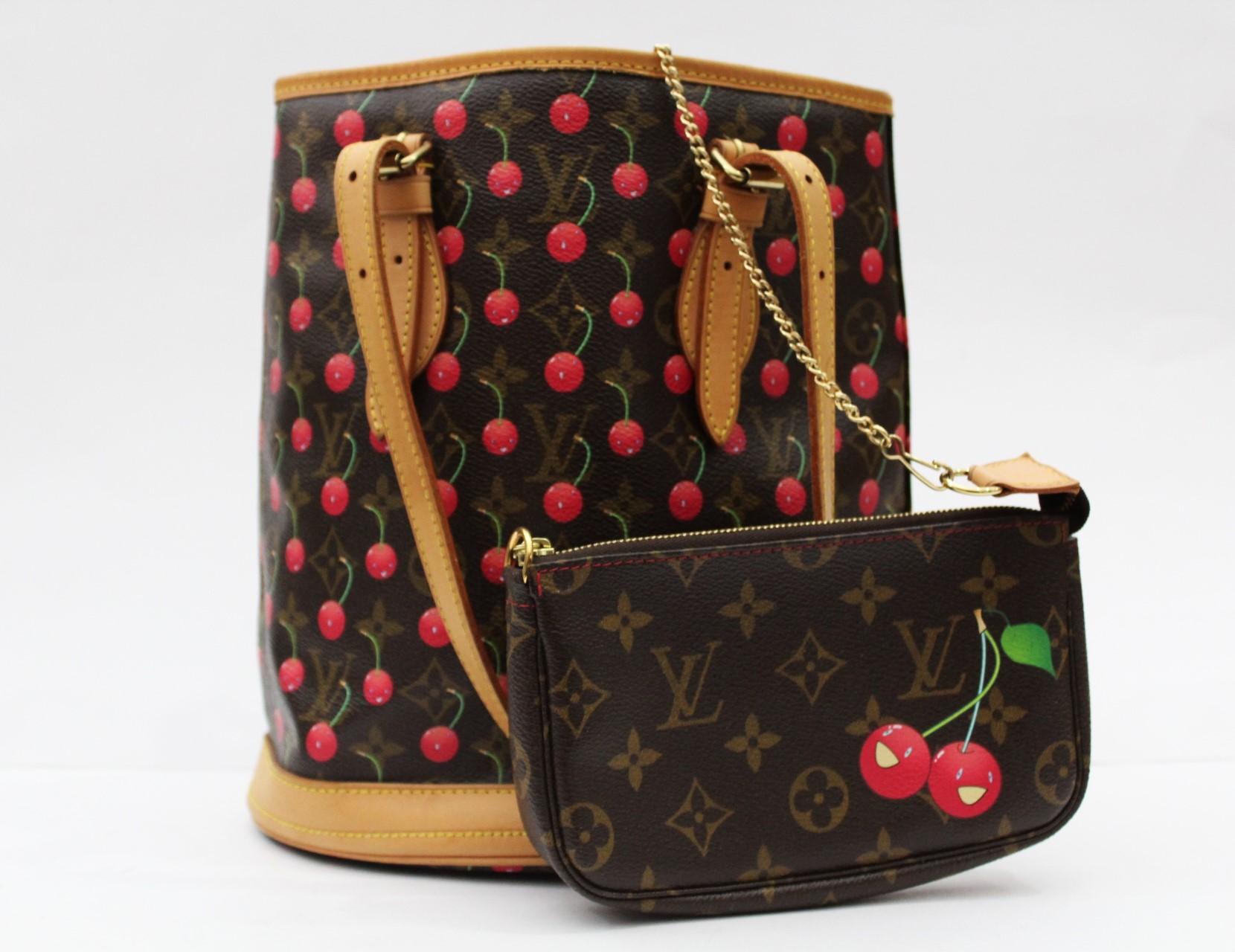 Limited edition Louis Vuitton Monogram Cerises Cherry Bucket Bag. This popular bucket bag style has the iconic monogram canvas adorned with bright cheerful cherries. It also comes with a removable Louis Vuitton Cherry Accessory Pochette that is
