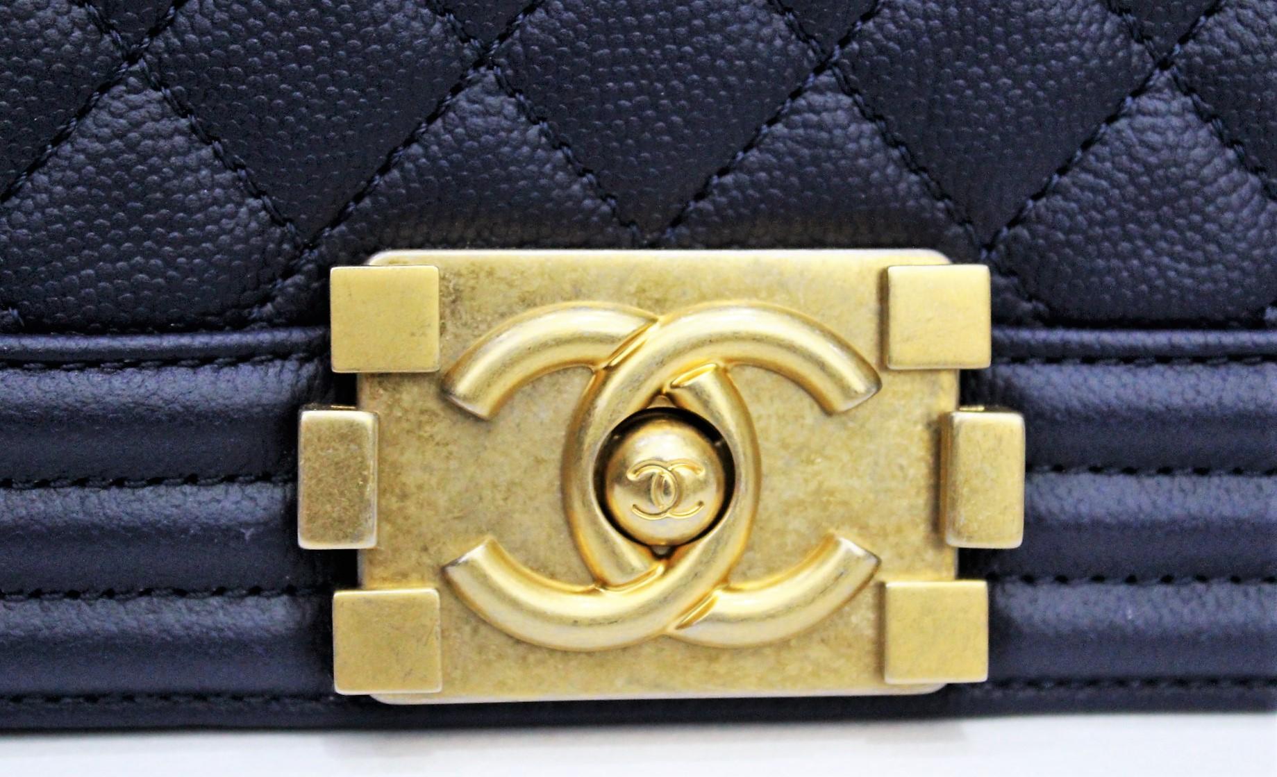 Fantastic Chanel Boy Mini in dark blue quilted lambskin with gold-colored hardware. The bag features a full front flap with CC signature push lock and gold color chain and blue leather shoulder strap. The interior is lined in blue fabric. We have
