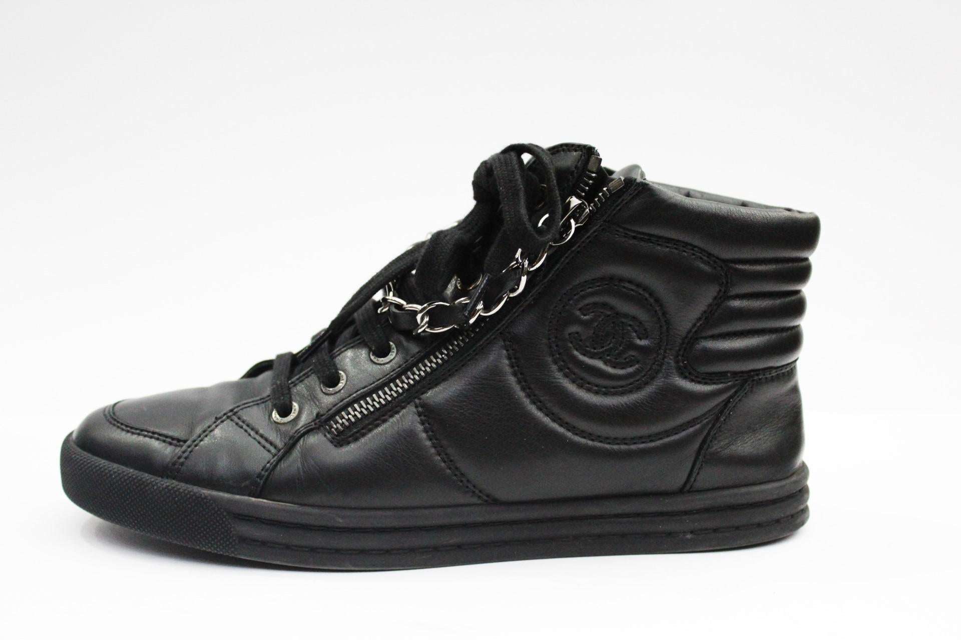 This comfortable Chanel sneakers are wonderful and exuberant. Entirely in black leather, with ankle boot with logo on the left side, laces and zippers with a pendant chain enriching the central part. Rubber sole and embossed logo. Number 38. Good