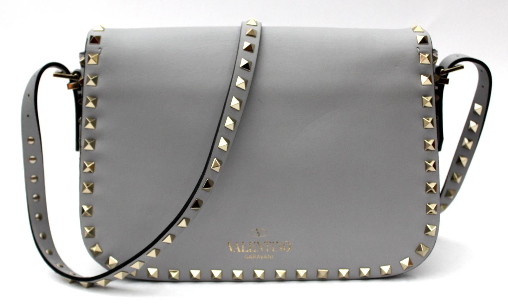 Valentino handbag Rockstud model in gtigia leather, typically covered with studs with structured shapes,
this collection is very sought after.
This medium-sized bag is perfect for when you want to travel light.
This bag has the classic Valentino