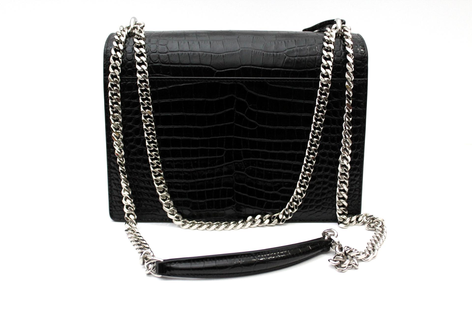 
Monogram Sunset Saint Laurent bag with a luxurious and exclusive design. This iconic model in genuine leather with crocodile print features a symmetrical cut from the rigid silhouette with a rectangular flap embellished with the symbolic and unique