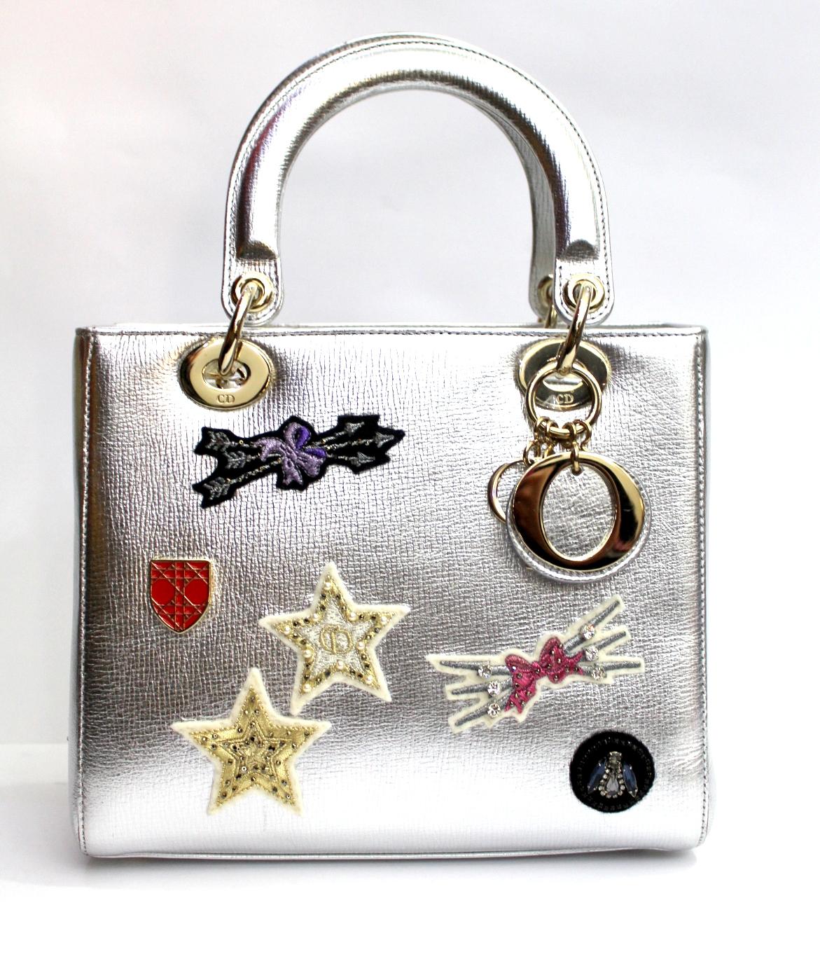 This authentic Christian Dior Lady Dior Patch Embellished Leather Medium presented in the brand's 2014 Collection mixes the timeless Lady Dior design with kitschy, work-of-art design made for the modern woman. Crafted from sleek silver leather with