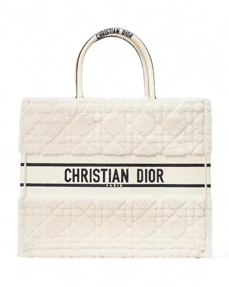 Borsa firmata Dior, modello Book Tote nella misura large, realizzata in montone d’agnello nella sofisticata colorazione ecrù, adornata dal motivo cannage. Non è dotata di nessuna chiusura, internamente rivestita in cotone tono su tono, la borsa è
