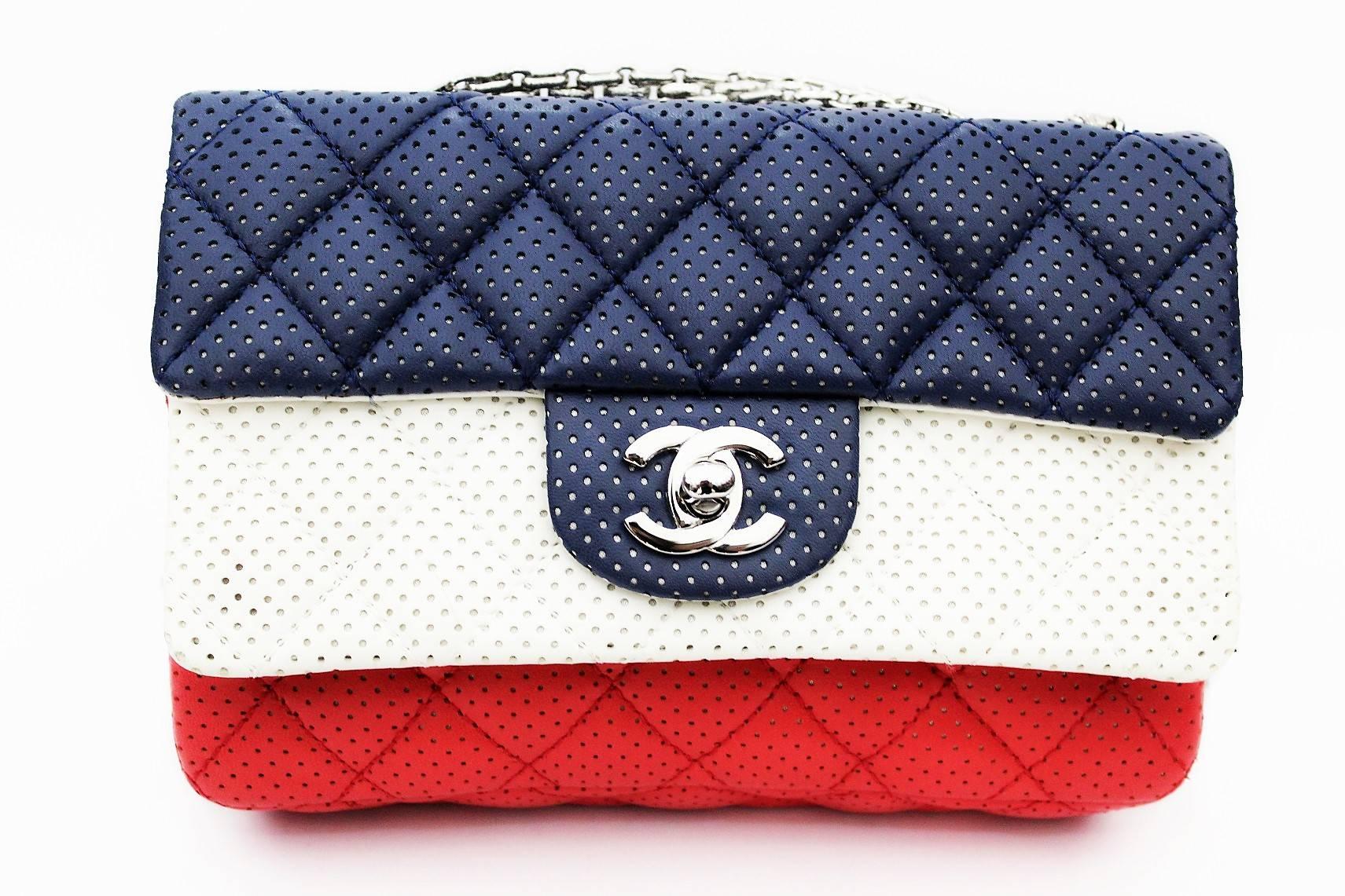 This is an authentic CHANEL Double Flap Perforated Leather Bag in a stunning white red and blue color. This beautiful piece of luxury is made from a quilted perforated leather exterior with matching silver-toned hardware. The Chanel Double Flap bag