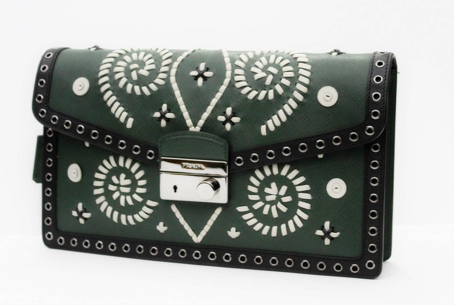 Green and Black Saffiano leather Prada clutch with silver-tone steel hardware, grommet and white embroidered accents, black leather lining.
