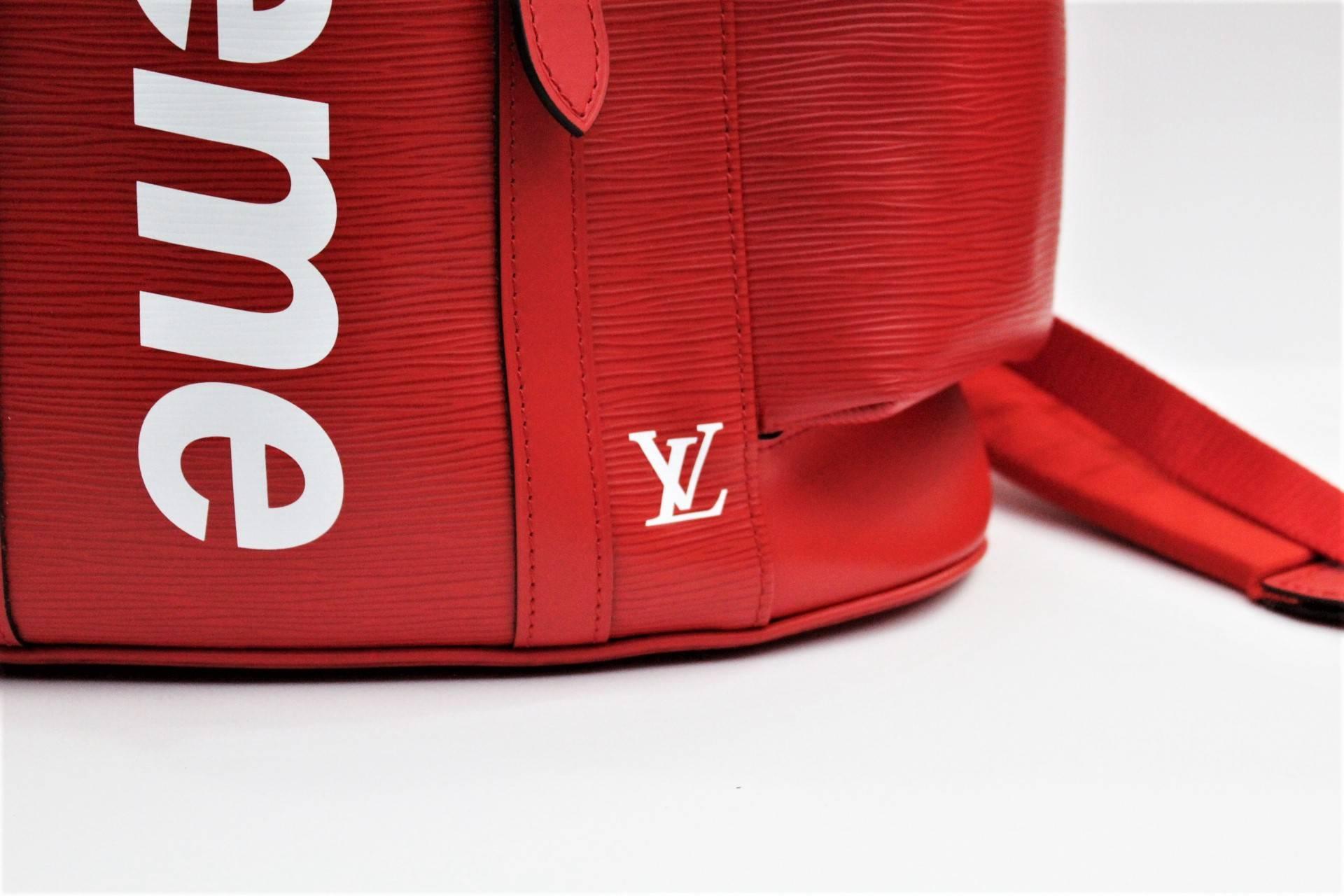 The Louis Vuitton x Supreme Christopher backpack in red is a structured bag dripping in style. It comes with adjustable leather shoulder straps, a leather top handle, flap opening, press stud and drawstring closure as well as several pockets inside.