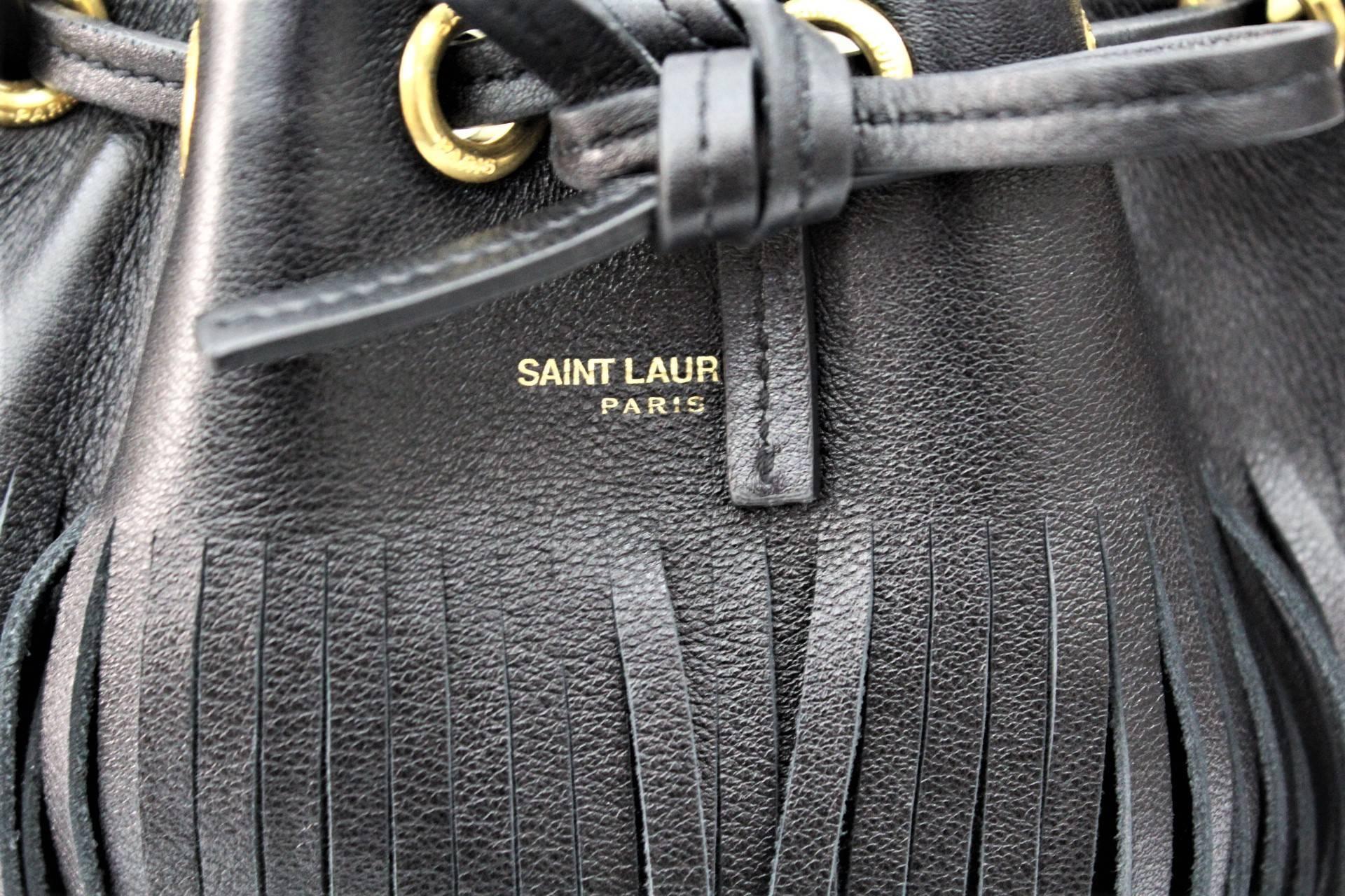 Black leather small 'Emmanuelle' bucket bag from Saint Laurent featuring a top handle, a drawstring fastening, a detachable and adjustable shoulder strap, a front center logo stamp and an internal logo patch.