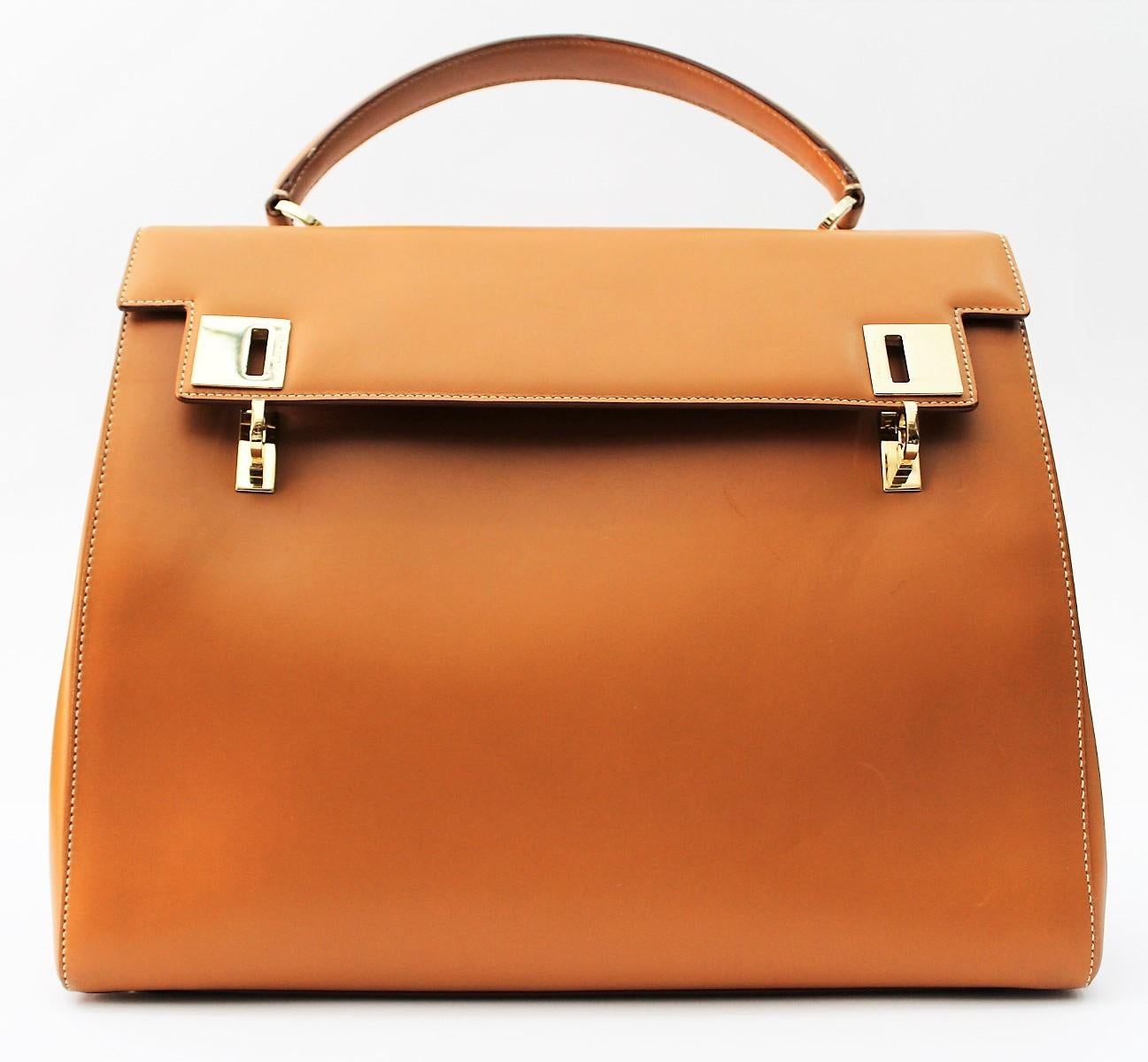 Salvatore Ferragano handbag in smooth camel-colored leather.
Wearable by hand through the upper handle, or on the shoulder thanks to the removable shoulder strap.
Inside there are three compartments and various pockets. Closing with hooks and gold