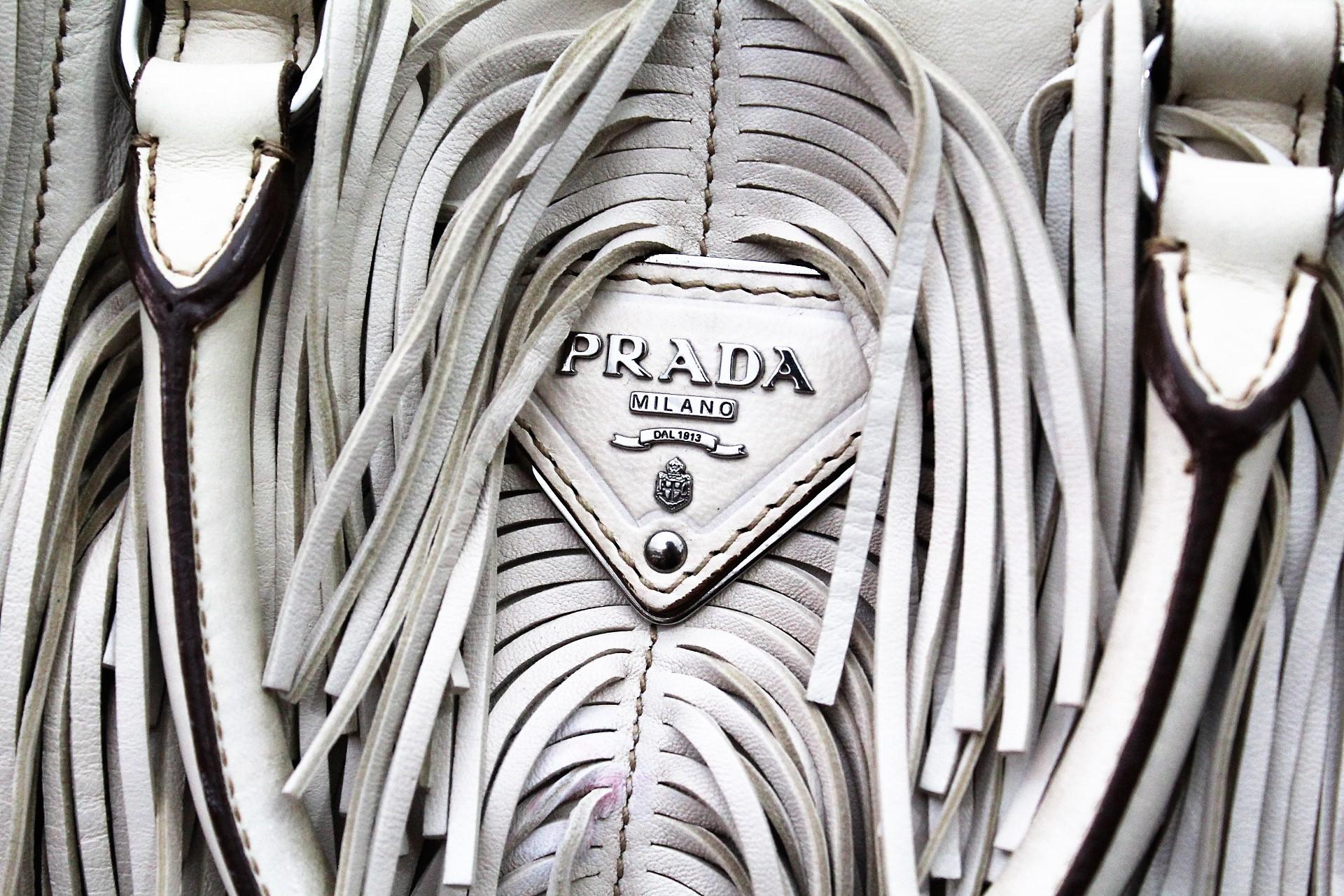 Prada bag in cream-colored leather. Completely enriched with fringes and studs that define the edges.
Fully lined, it is equipped with two compartments with clip closure and
a large internal pocket with zip.
Wearable by hand thanks to the two