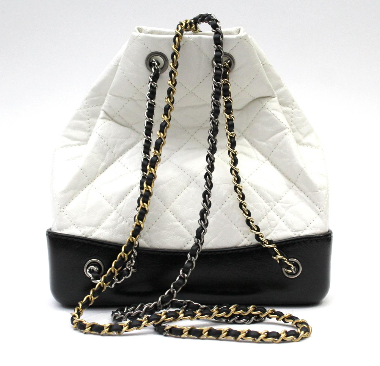 Chanel Gabrielle backpack in white aged calfskin and smooth leather rigid bottom. Chains are gold, silver and ruthenium. Hologram intact and matching authenticity card. Measurements: H 22cm W 22cm D 10 cm (on the rigid part) 