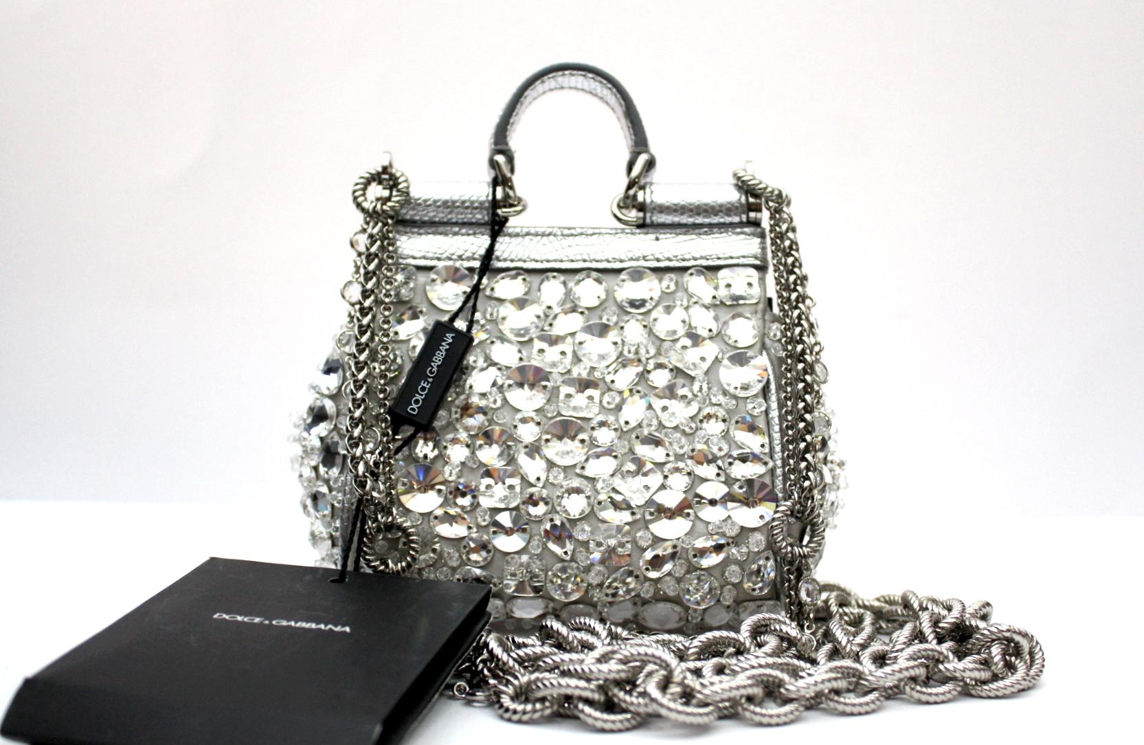 Micro bag of Sicily line in satin with embroidery with matching crystals and jewel shoulder strap:
• Front flap with hidden pressure closure
• Top handle and profiles in laminated iguana printed calfskin
• Jewel chain in palladium and crystal