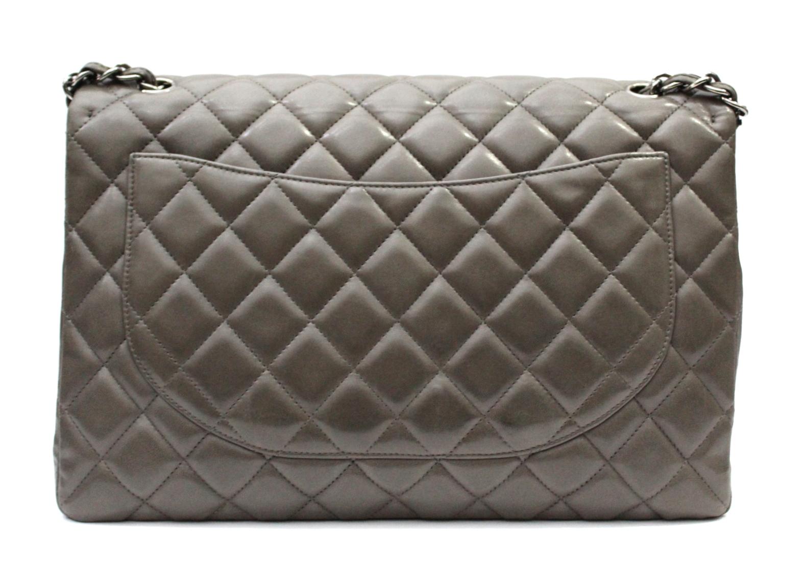 The Chanel Maxi Jumbo in dove-gray quilted smooth leather, is perhaps the most sought-after bag in the classic Chanel collection, which continuously increases in value. This bag features a CC closure with silver padlock. The versatile chain and