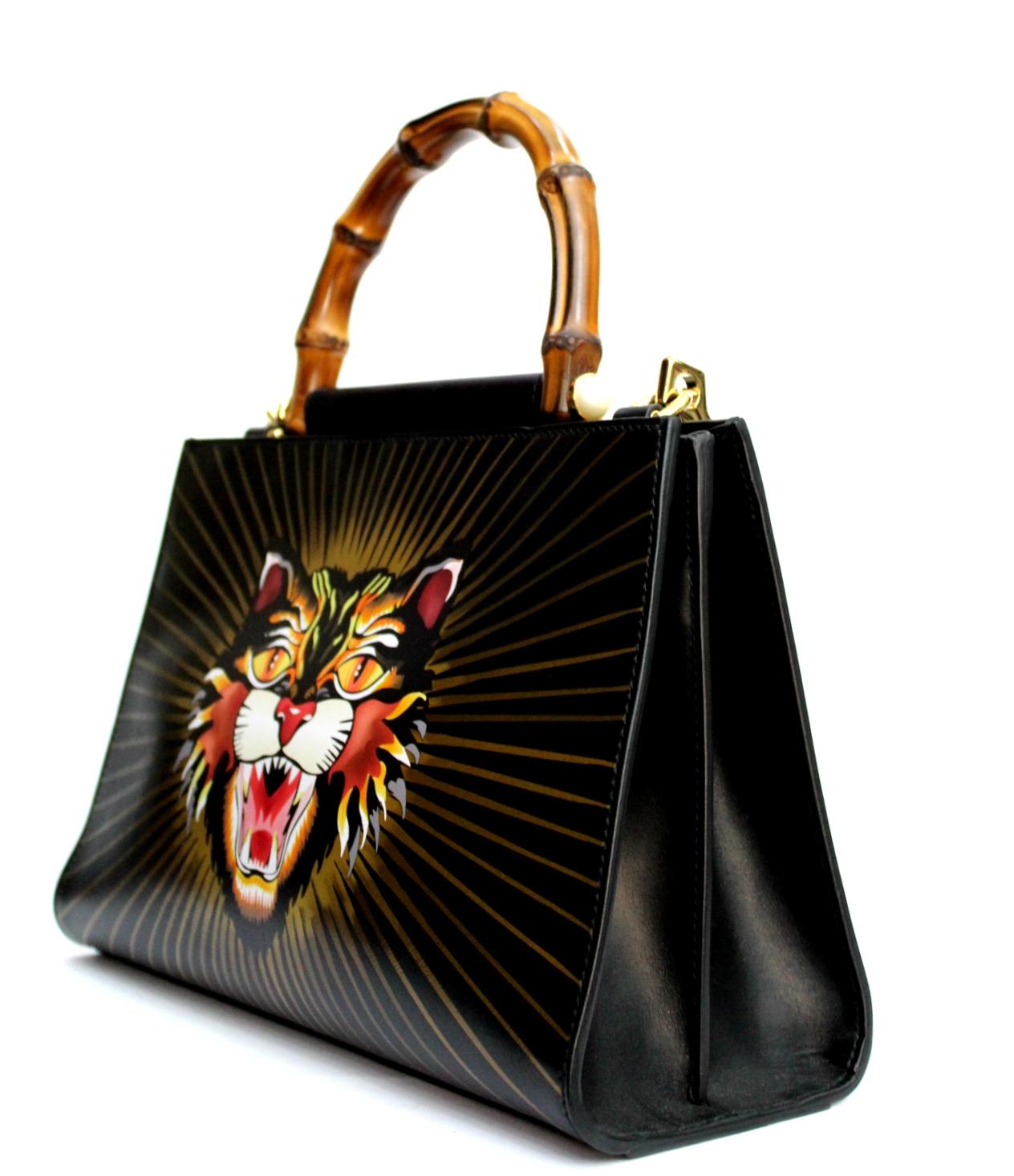
Fantastic Gucci Nymphea model. The bag is made of leather and has a bamboo handle, but to characterize it is the print of an angry cat. The bag consists of two compartments, both with magnetic closure and is equipped with a removable shoulder strap
