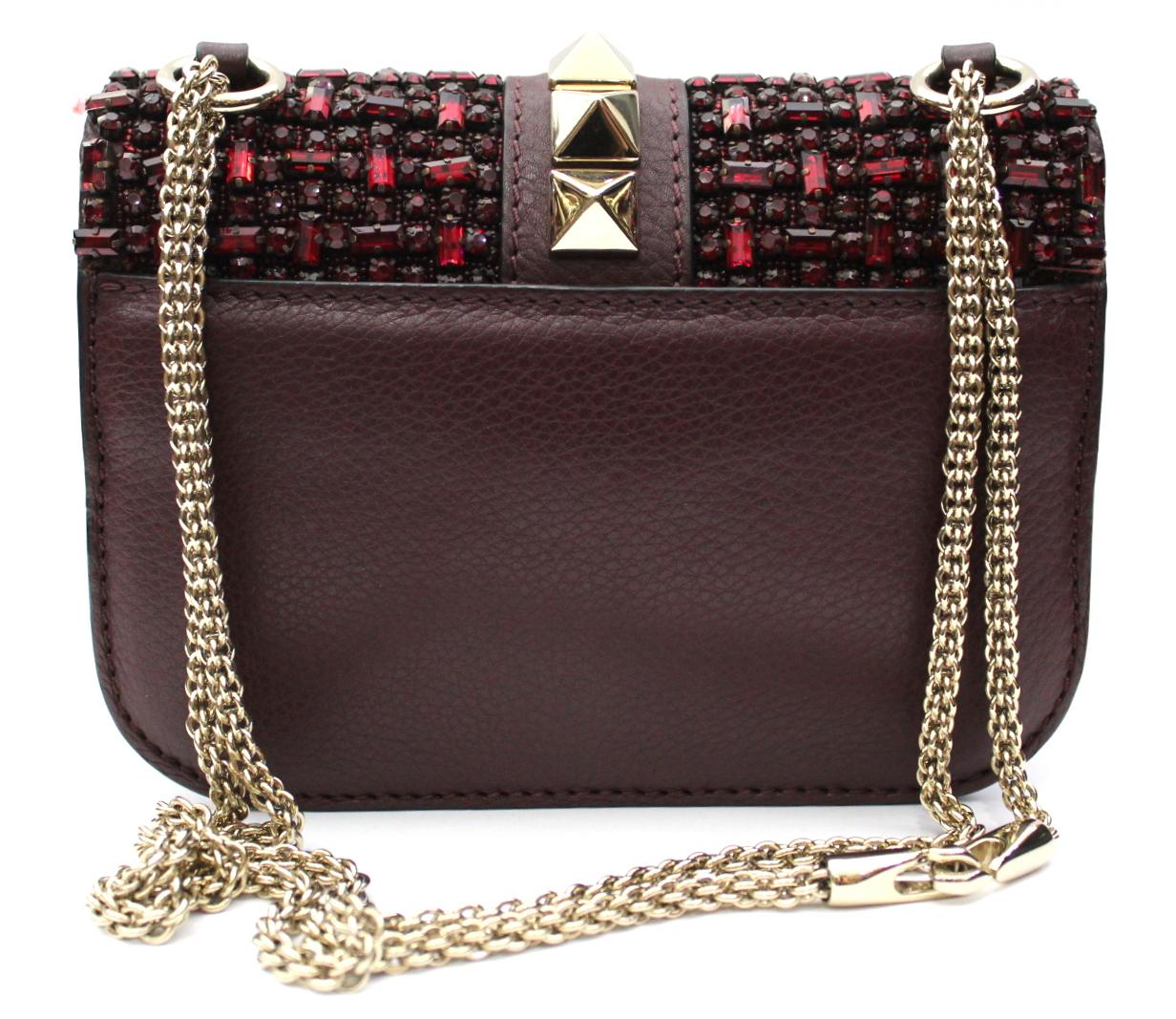 Sensational Valentino bag shoulder bag embellished with numerous rhinestones. The color of the bag is burgundy while the chains and studs are light gold. Internally it is lined with a soft skin. The conditions of the bag are like new.