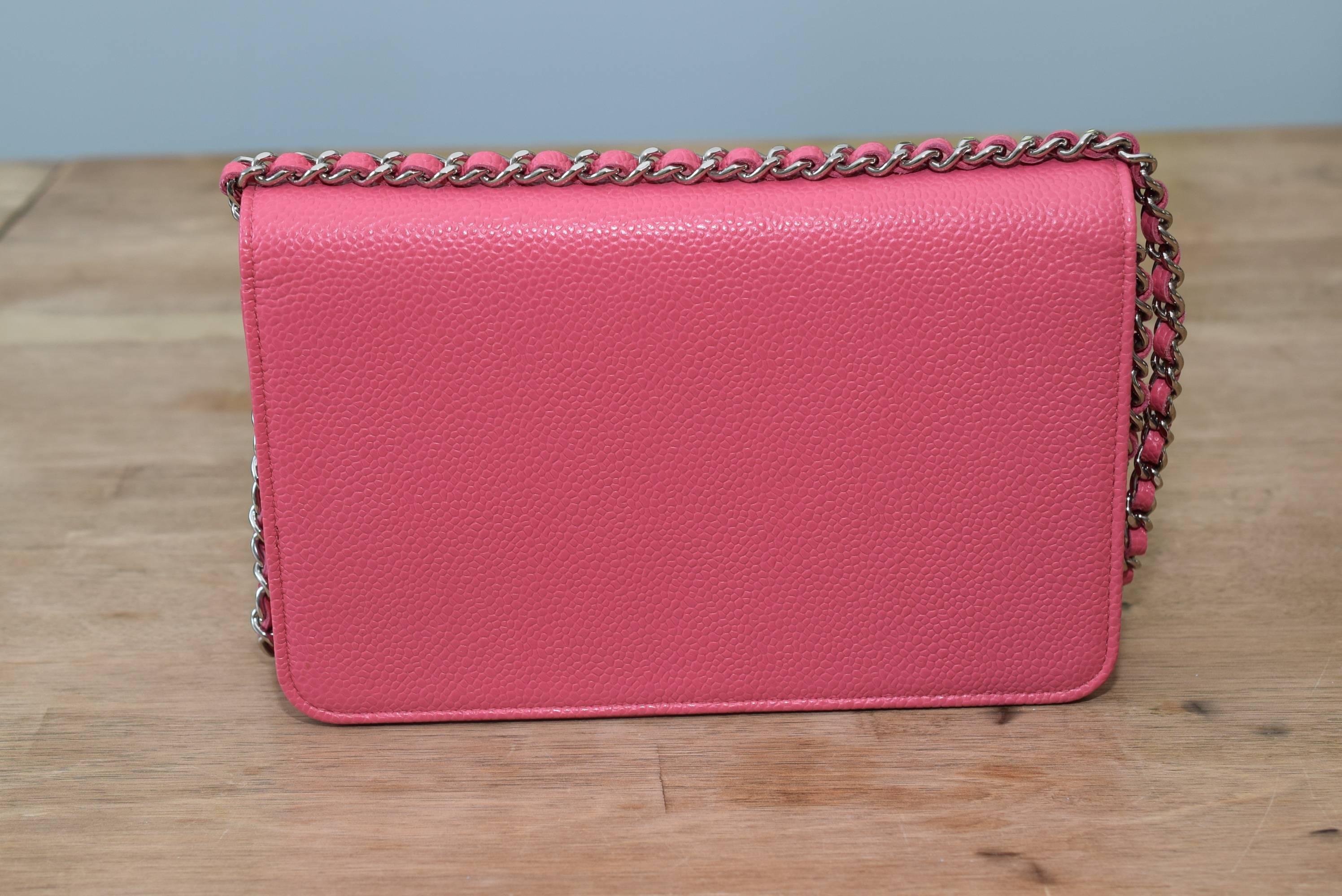 Brand new, never worn Chanel Timeless Wallet on Chain in Pink Caviar with silver tone hardware features a front flap with tonal stitched large CC, hidden snap closure, expandable sides and bottom, along with a silver tone and pink leather strap,