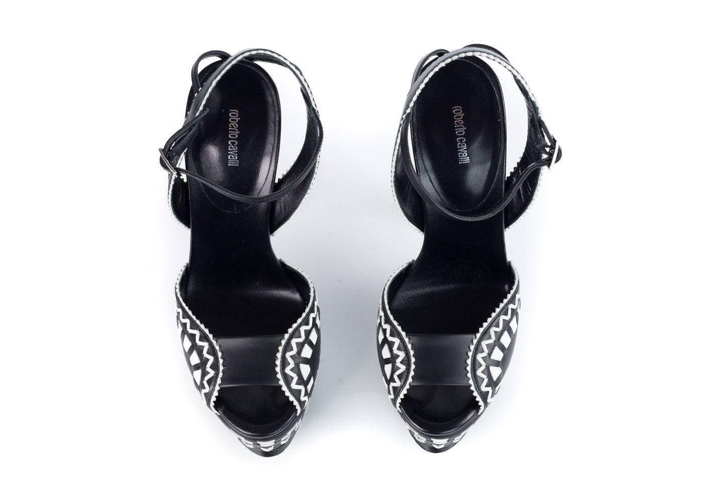 
Black and white textured tribal pattern leather Roberto Cavalli platform sandals with buckle closures at ankles.These are the perfect Pumps for a saturday night out with its high and eye catching hits accents and super high height. Simply wear it
