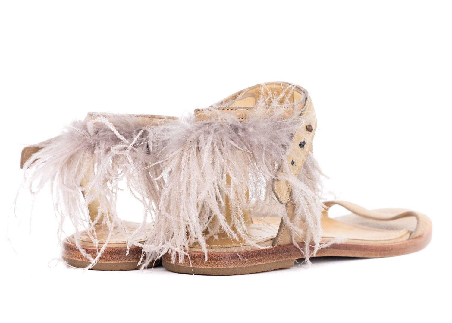 Enjoy your wild side in your Brunello Cucinelli Sandals. This light brown sandal features a grained leather, light grey feather infused ankle strap, and wooden sole. Start your day by pairing this beauty with an tonal shift dress for feminine