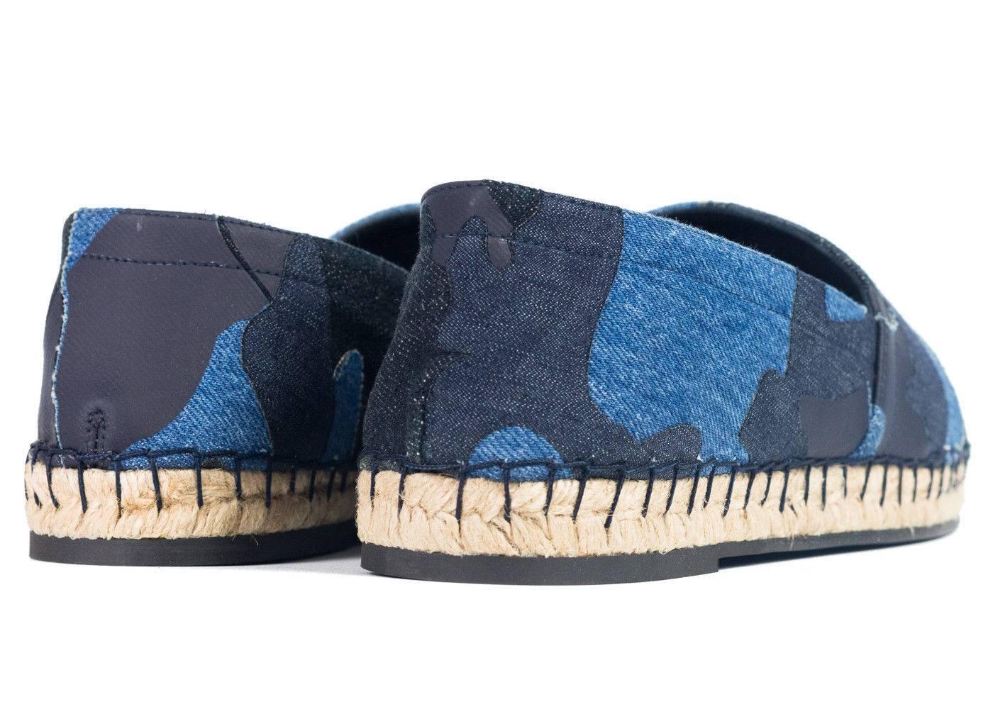 Canvas espadrilles featuring camouflage pattern in tones of 'army' Blue and black throughout. Woven accent in taupe at round toe. Blanket stitching at welt. Braided jute midsole. Rubber sole in tan. Tonal stitching. Perfect for a pair of Jeans a