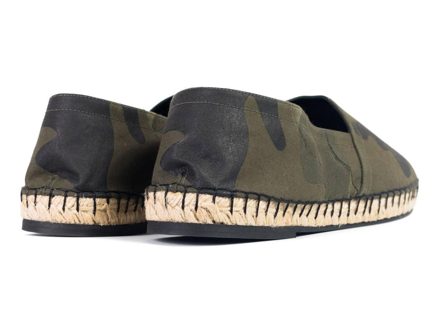 Canvas espadrilles featuring camouflage pattern in tones of 'army' green throughout. Woven accent in taupe at round toe. Blanket stitching at welt. Braided jute midsole. Rubber sole in tan. Tonal stitching. Perfect for a pair of Jeans a Black