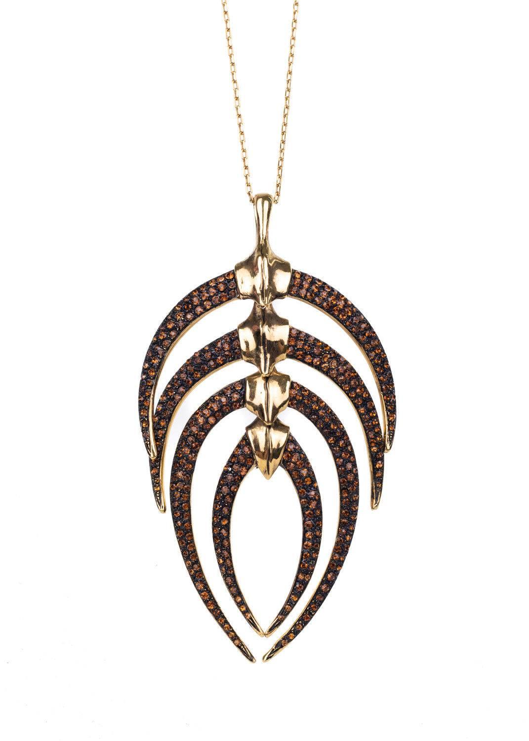 Roberto Cavalli gold plated pendant necklace featuring bronze swarovski crstals made into the shape of a leaf. This pendant necklace is a great contribution to an all black outfit. Pair it with a black dress for this necklace to stand out within the