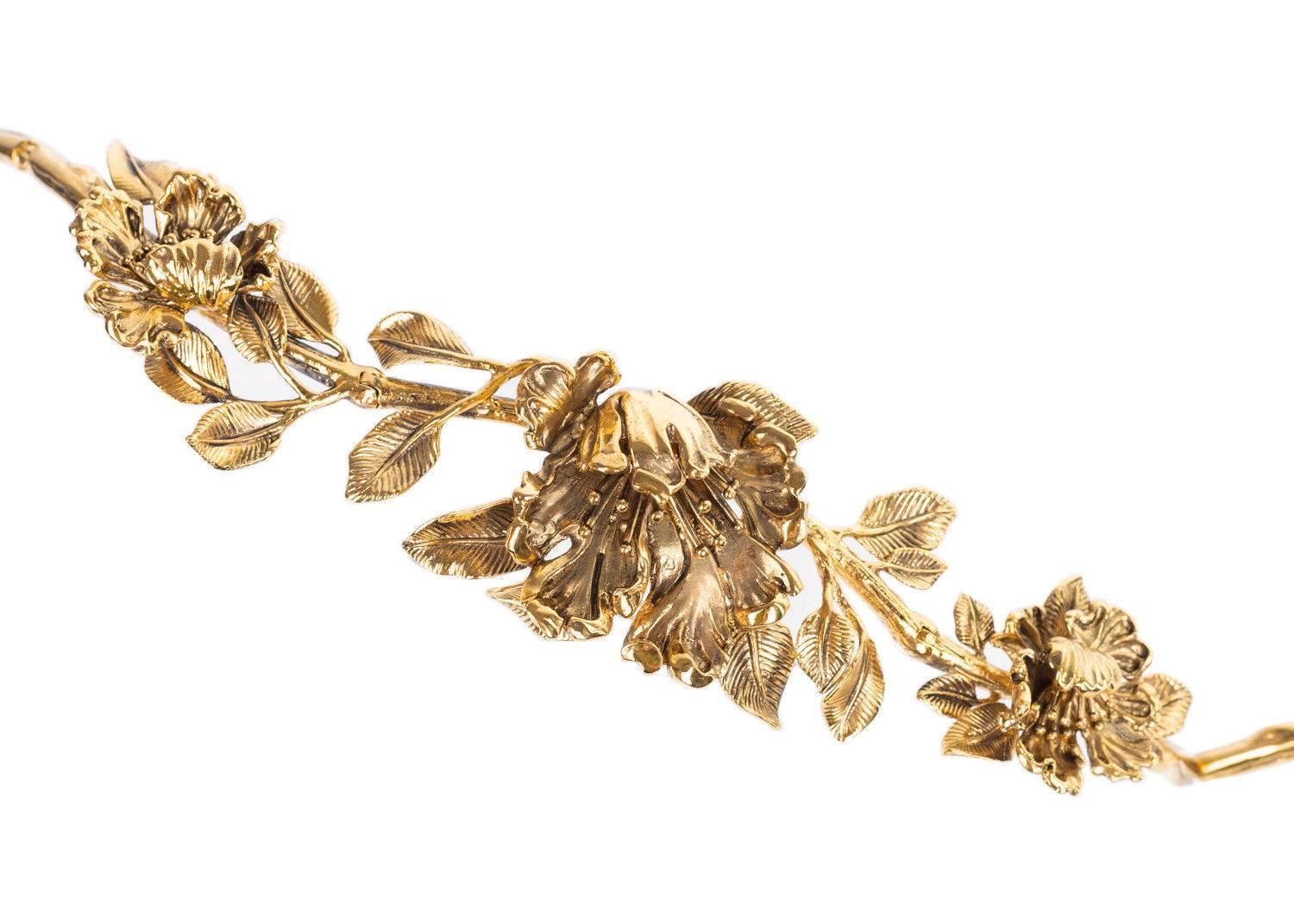 Roberto Cavalli blossom design in a gold plated finish with a lobster clasp fastening. This gold plated belt can be worn as a waist belt for a pop in your look. Pair it with high waisted jeans a white blouse and this gold blossom belt for a chic