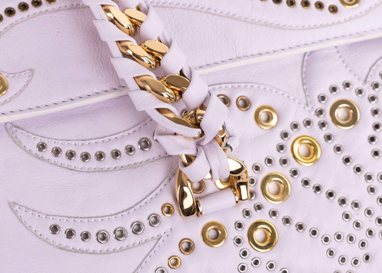 Regina Medium White Radiant Studded Satchel Bag crafted in lambskin leather lends a boho chic style with its soft lines and radiant pyramid and pindot studs. Featuring inlaid chain and leather handles internal zip and slip pockets Leather lining and