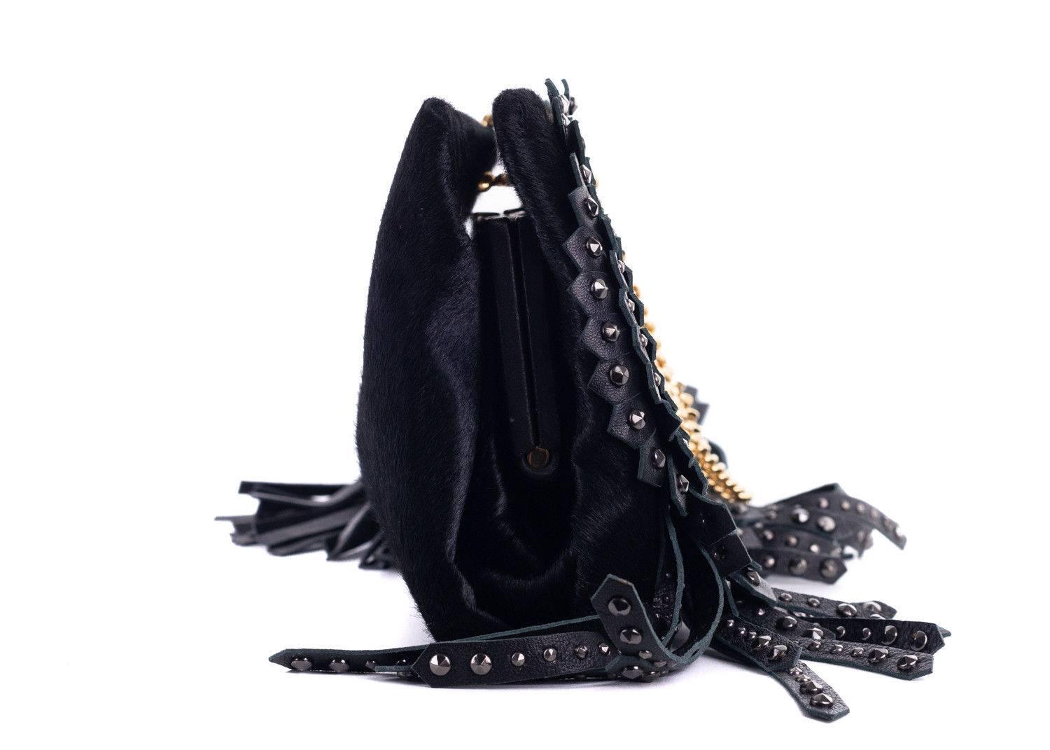 Roberto Cavalli black clutch made with calf hair and calf leather. This clutch features gold tone hardware with two large black tassels and studded fringe detailing. Pair it with an all black ensemble at night for this bag to pop.

 

Leather  Calf