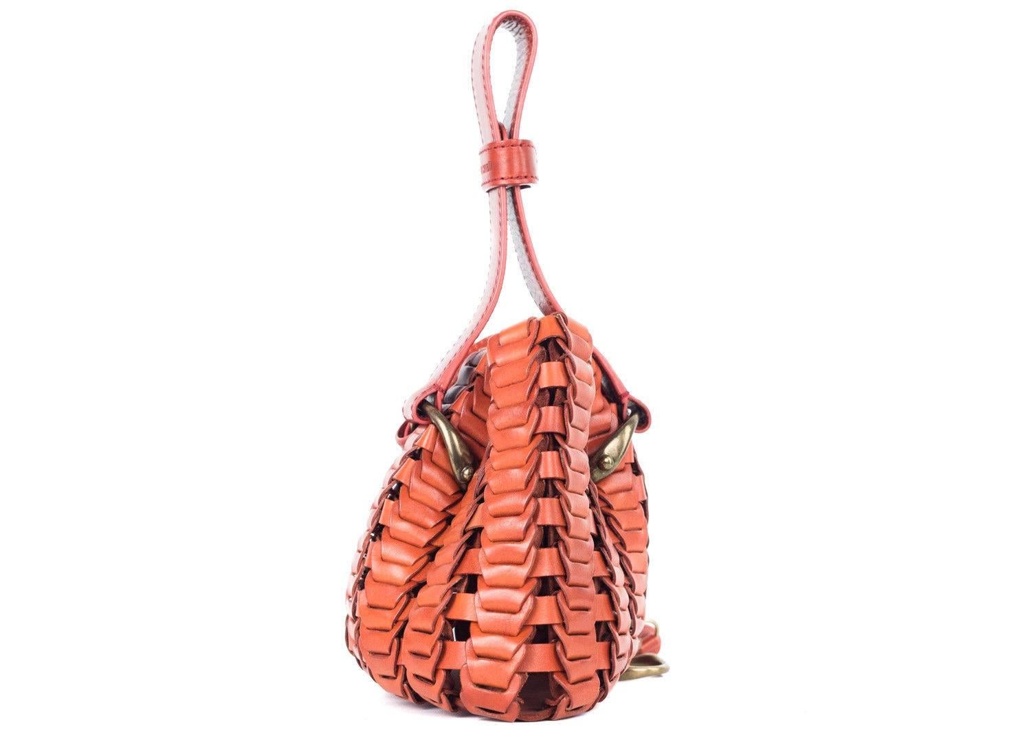 Roberto Cavalli copper orange bucket bag. This bag features a knit like pattern with a matching tassel and horse ornament on the tassel. Perfect for the incoming summer season, pair it with denim shorts and a cute floral top and sandals for a chic