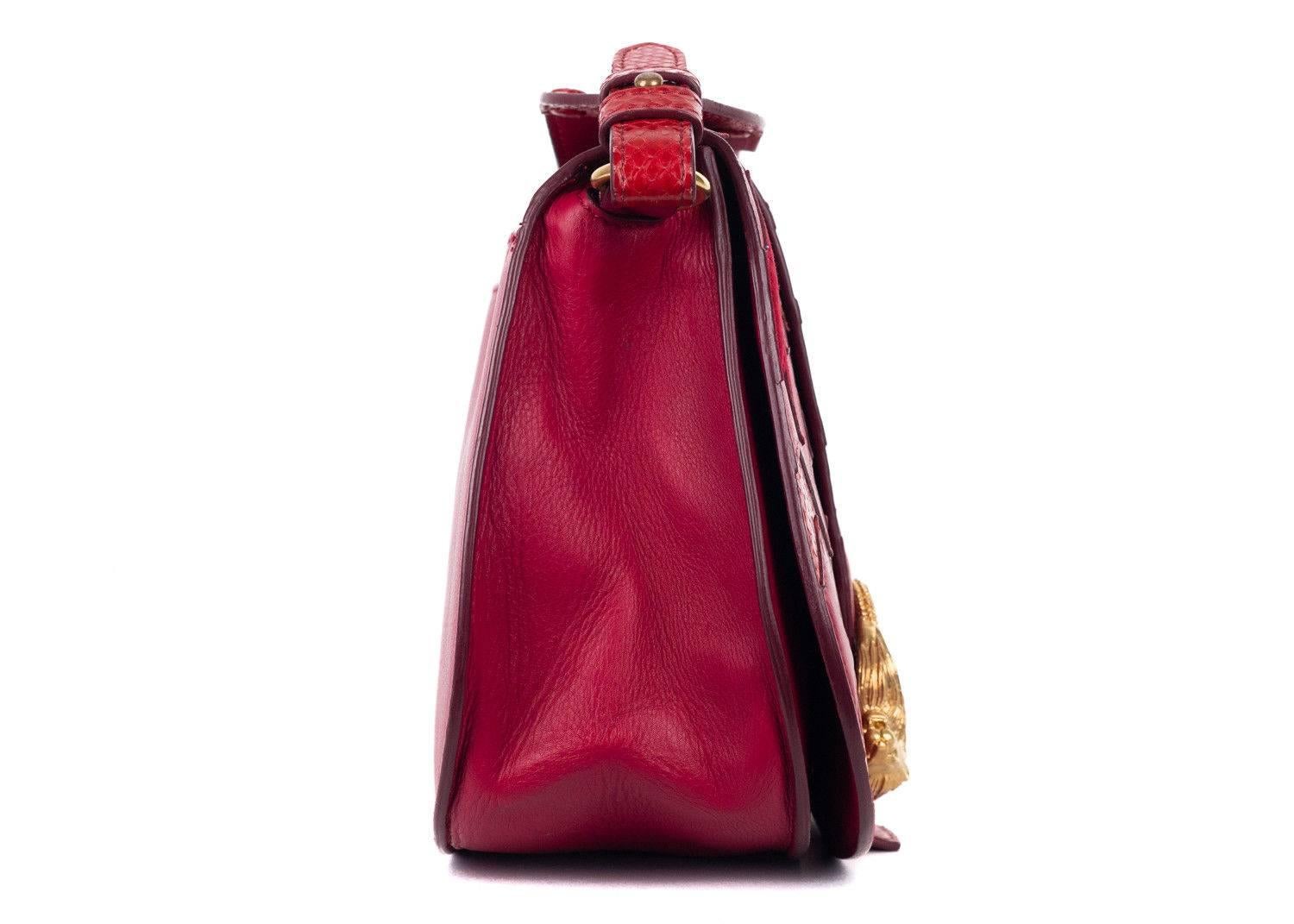 Roberto Cavalli red leather shoulder bag. This shoulder bag features snake embossed print sar detailing and a lion gold pendant in the front. This bag is sure to give a pop to your everyday style with its bold color. Pair it with simple jeans and