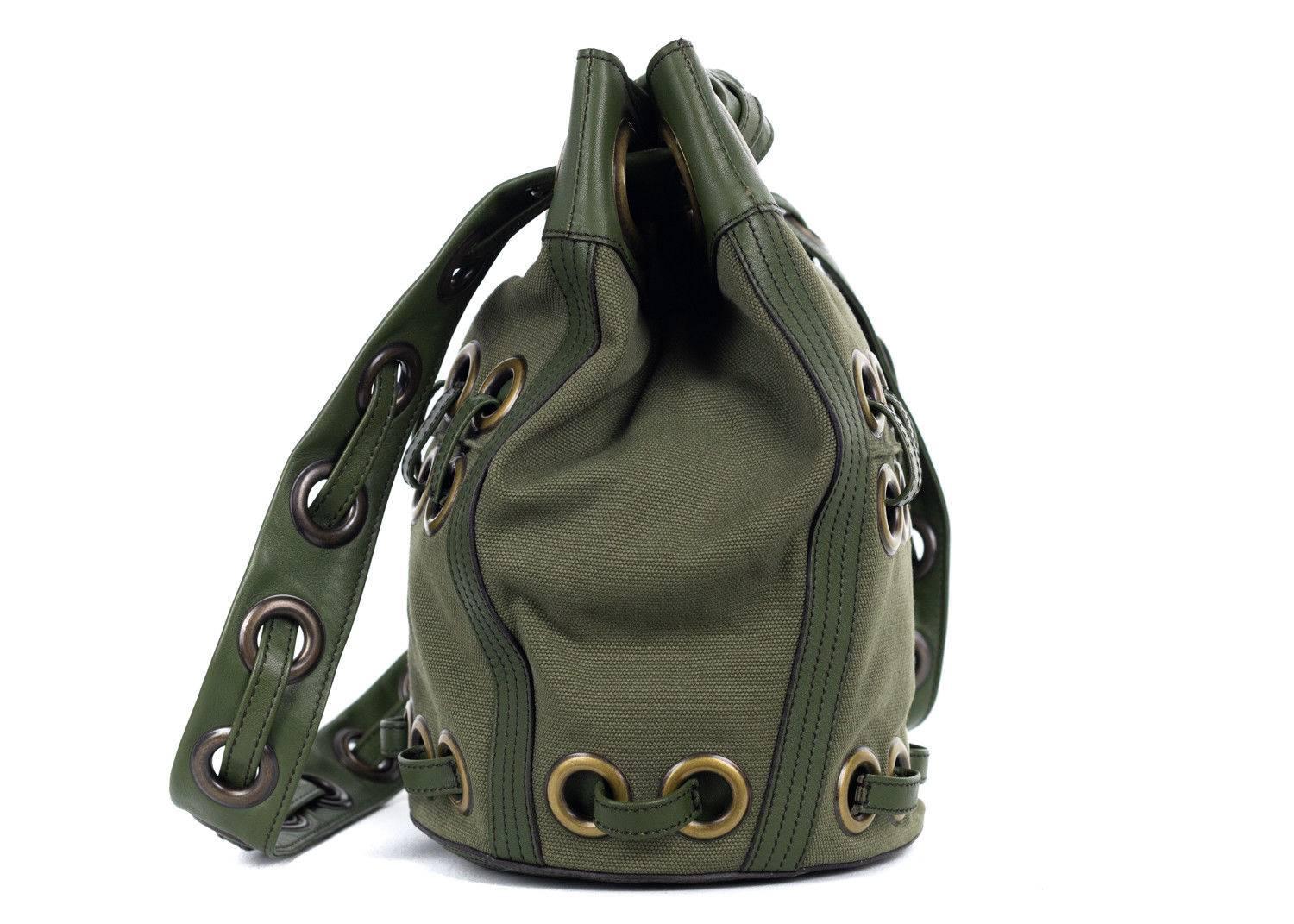 Roberto Cavalli solid army green canvas and leather bucket tote bag. This bag features large eyelet detailing with dark toned hardware. Spice up your everday style with this edge tote bucket bag by wearing simple denim and chic blouse.

 

Leather