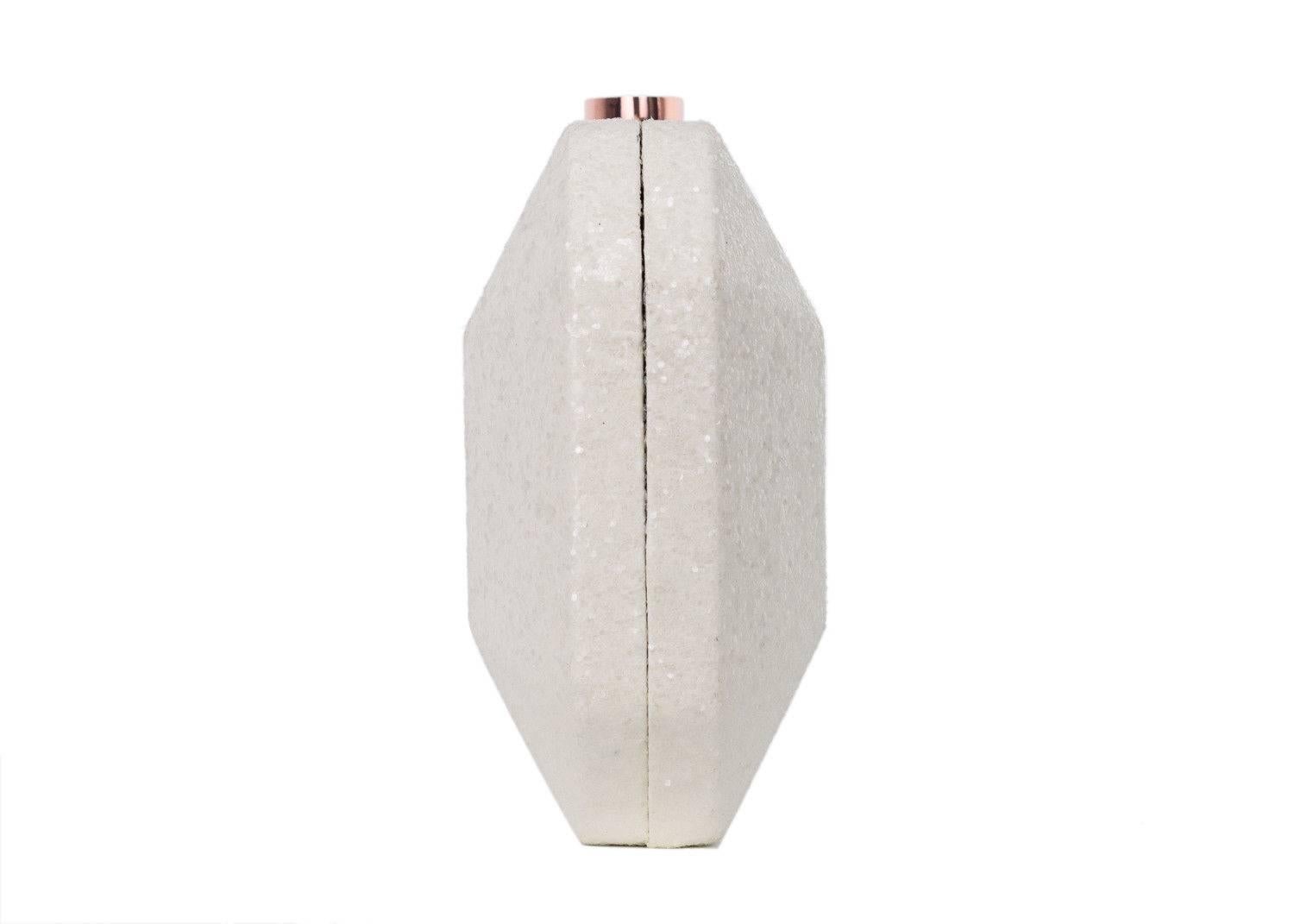 Just Cavalli white ivory clutch bag. This clutch bag features shiny glitter detailing throughout the bag with a matching rose gold buckle in a push lock closure. This clutch is perfect for evening wear or special events such as parties and prom.