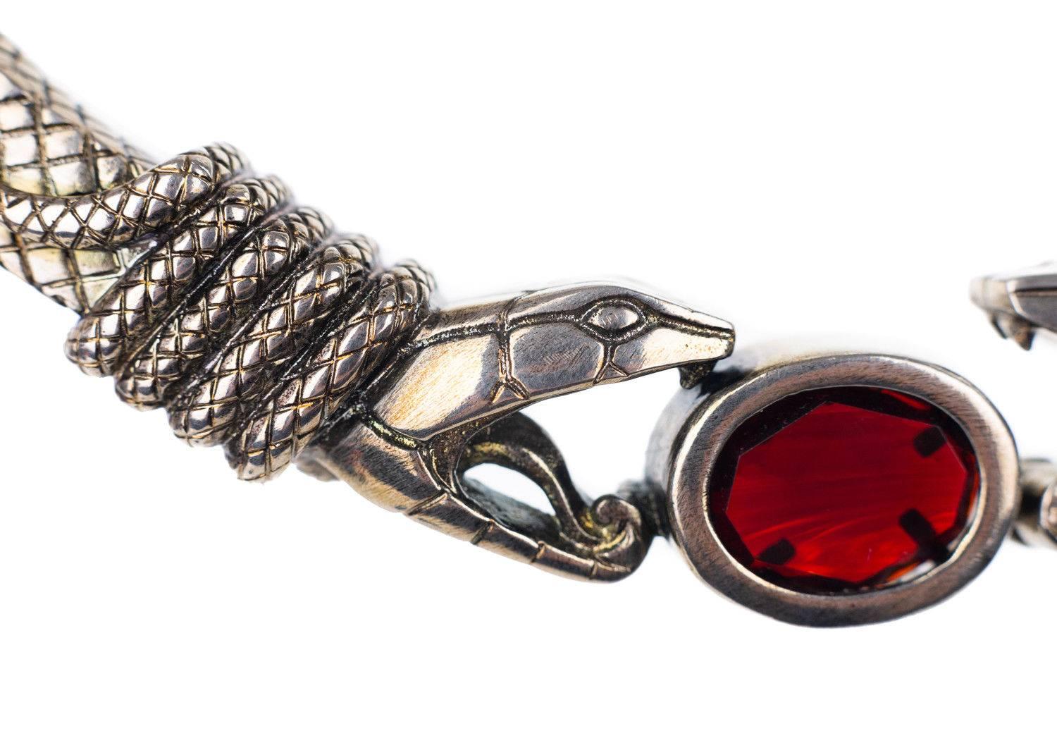 Roberto Cavalli silver plated choker necklace. This necklace features serpent detailing and a red stone gem in the middle of the necklace. Perfect to style with on an all black ensemble for a bit of edginess to your style.

Brass
Silver