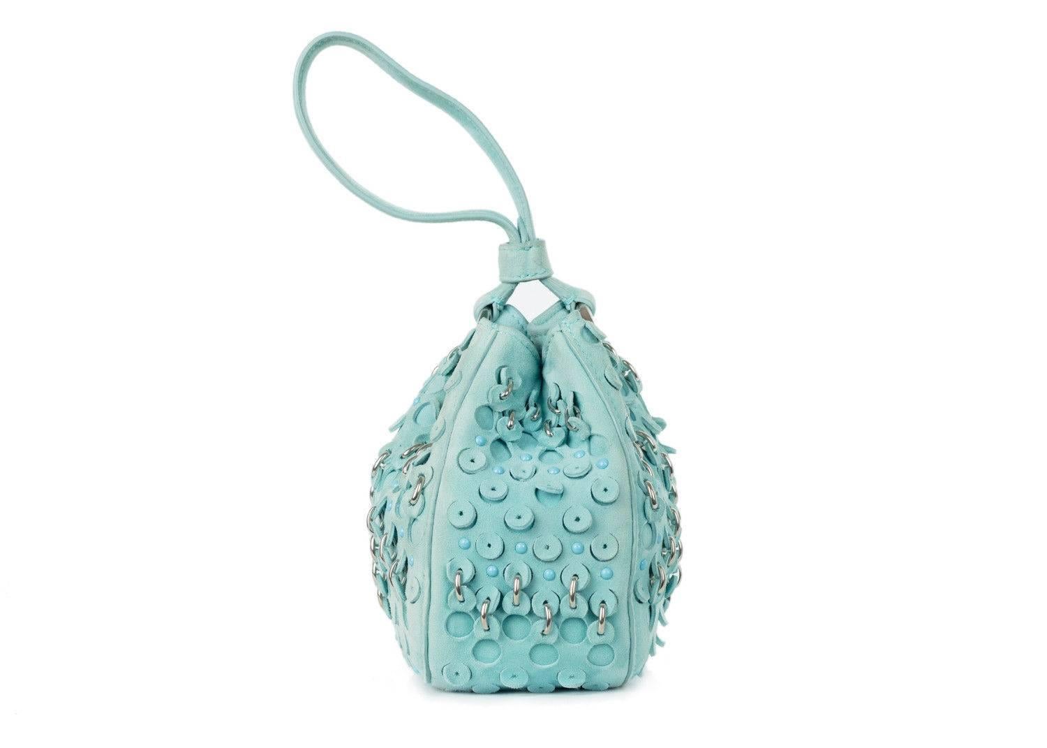 Roberto Cavalli turqouise suede wristlet bucket bag. This bag features eyelet patterns studded accents and a wristlet. Perfect summer bag, this bag can be paired with dark wash shorts or denimm with a floral top and sandals for this bag to pop.

