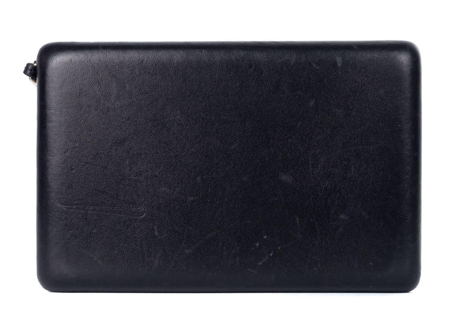 Roberto Cavalli black leather clutch bag. This clutch bag features a solid black leather with a contrasting gold tone hardware a horse ornament with long fringes attached. This clutch can be worn as a day wear bag or night wear. Perfect for any