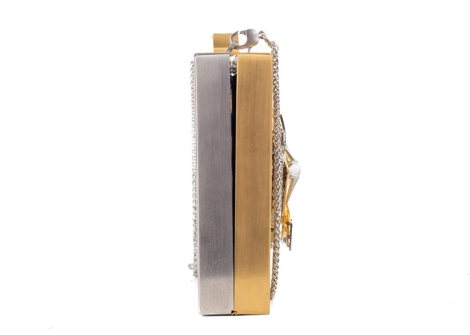 Roberto Cavalli gold metal clutch. This clutch can be worn on the shoulder with its detachable shoulder strap. Emebllished with crsytal detailing, this piece is eye catching and sure to stun in the crowd

 

Brass
Gold Metallic Front and Silver