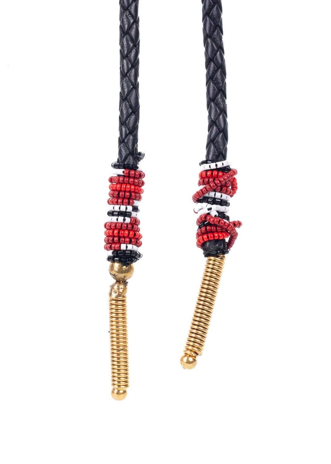 Get your Roberto Cavalli Necklace for the western style decadence. This necklace features a black leather braided chain, smooth black stone embellished gold pendant, and cultural micro beaded gold tipped tassels. You can pair this necklace with a